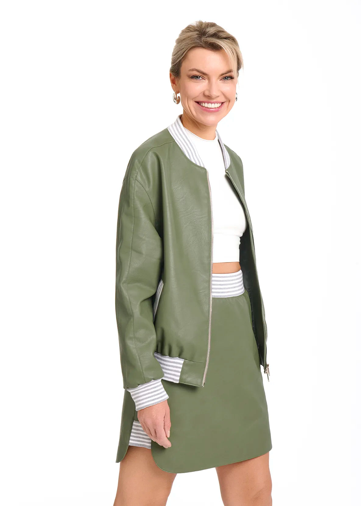 A woman dressed in a green Mimaussy Paris bomber jacket and skirt, reflecting 90s fashion trends.