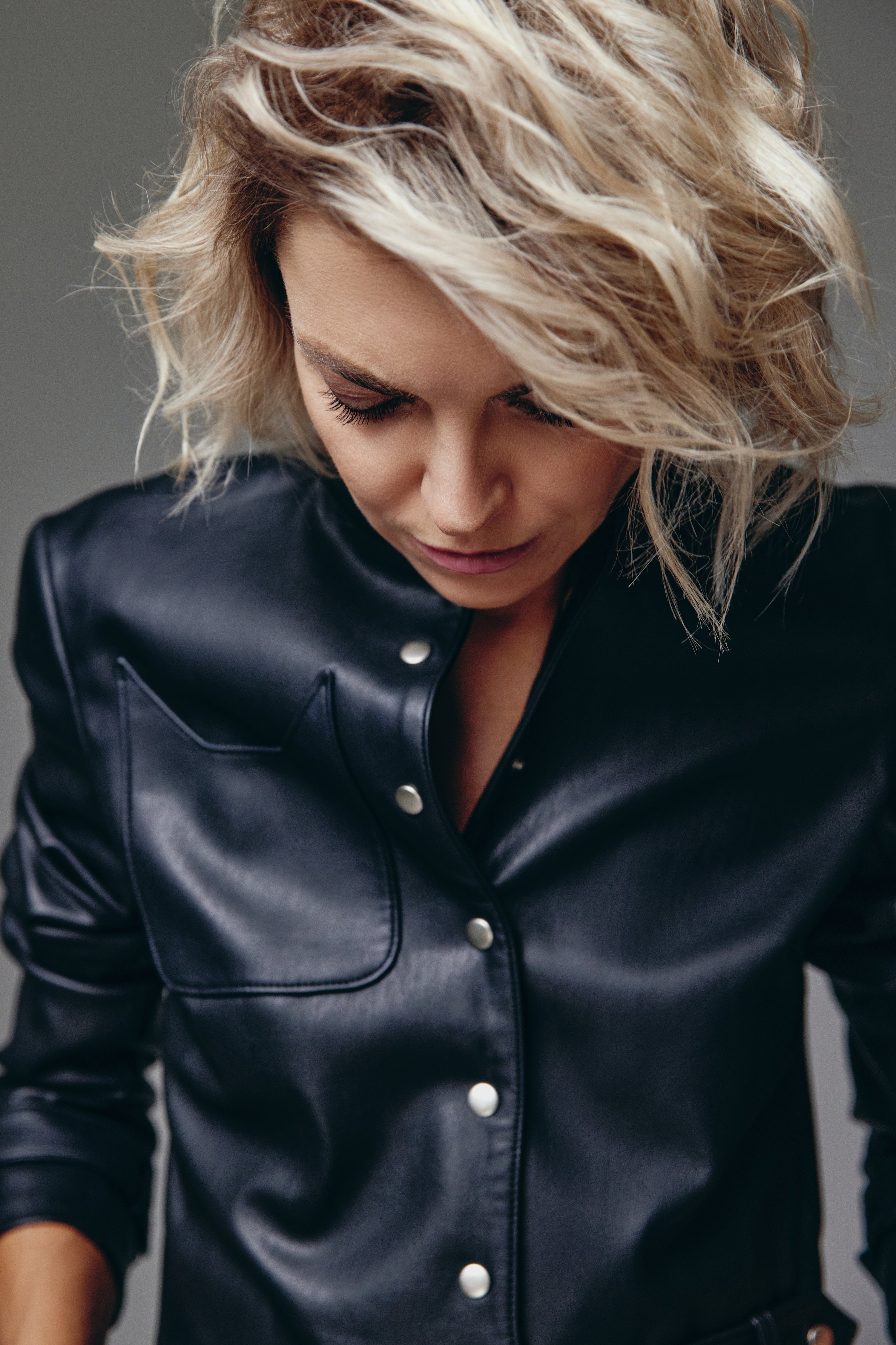 Woman wearing a Black Catty Jacket from Mimaussy Paris, close-up front view, model looking down