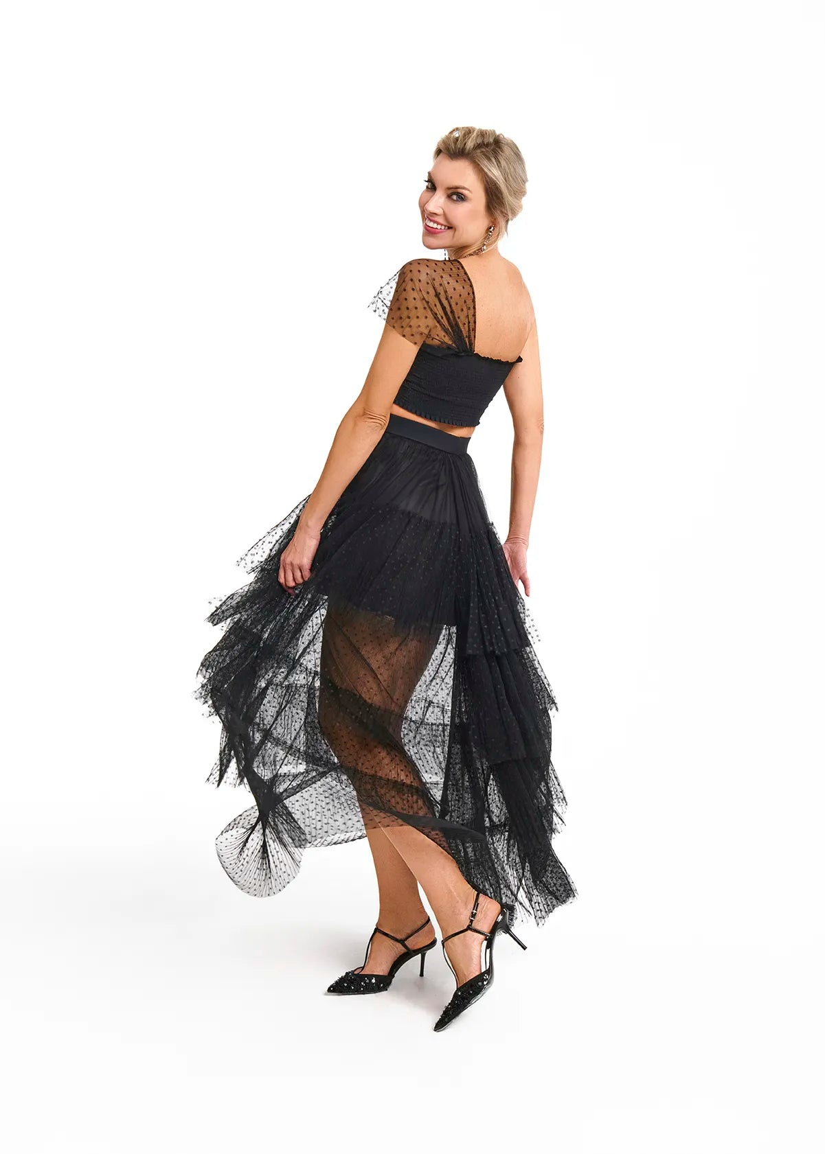 A woman in a black Souflé Skirt from Mimaussy Paris poses confidently for the camera.