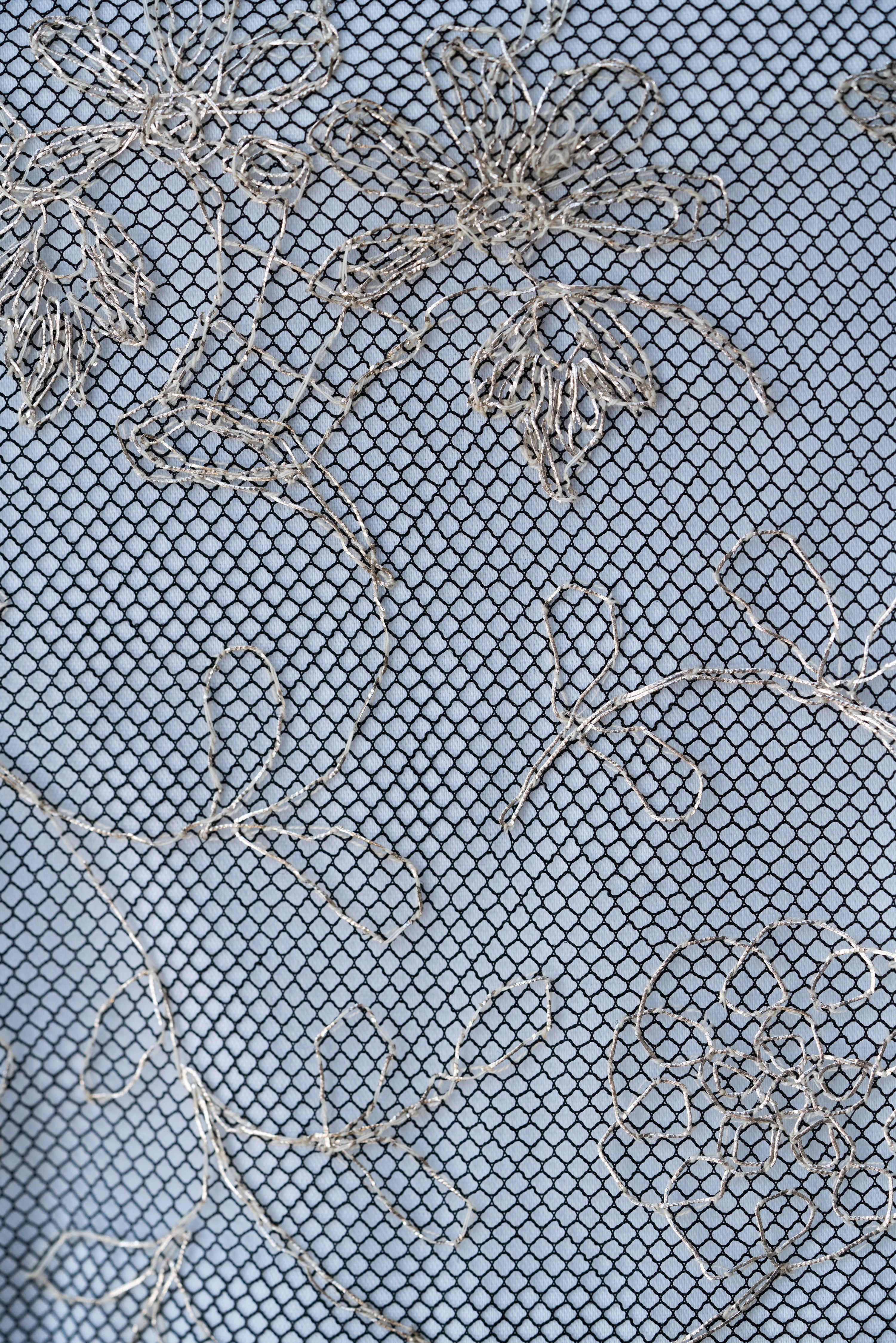 Textured fabric of Blanc de Pouvoir from Mimaussy Paris with grid pattern and embroidered designs on blue background