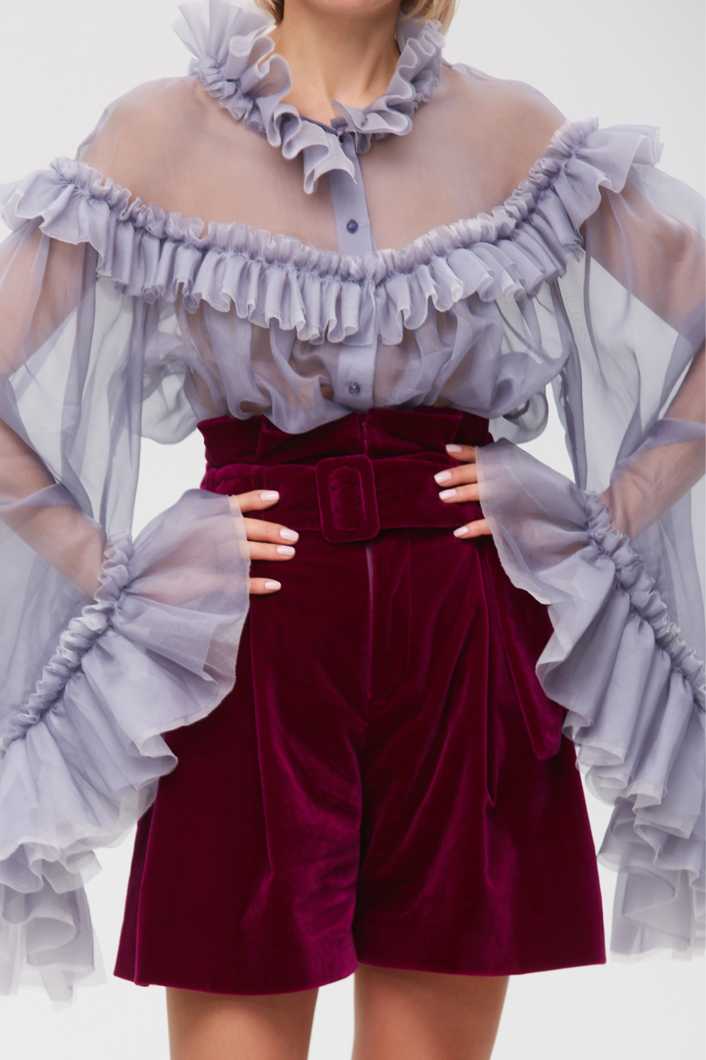 Woman wearing Burgundy Icon Shorts from Mimaussy Paris, studio close-up of front details with off-shoulder ruffled top against a plain white background