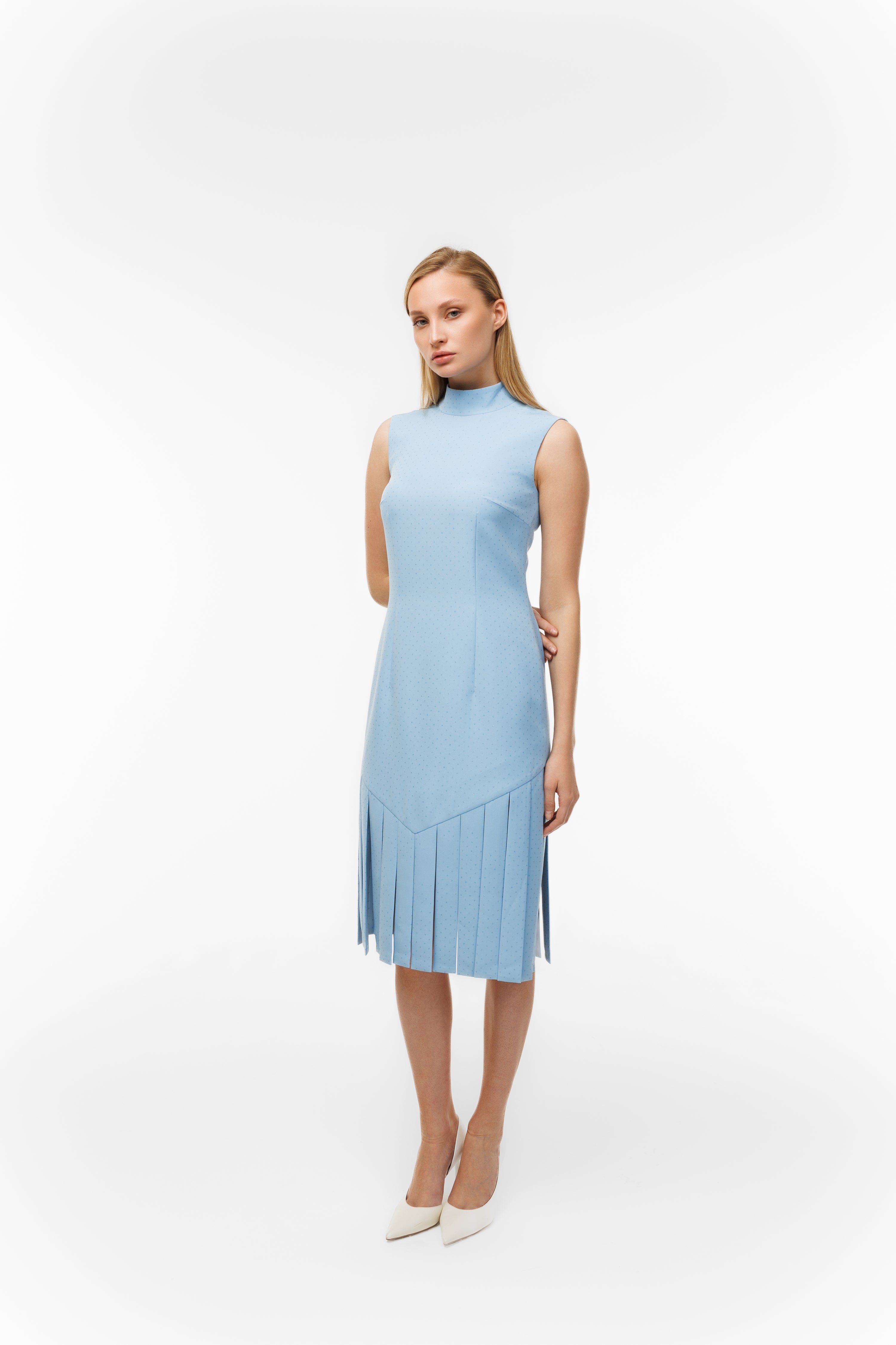 Woman wearing Charlestone Sky Blue from Mimaussy Paris, light blue dress against white background, studio setting