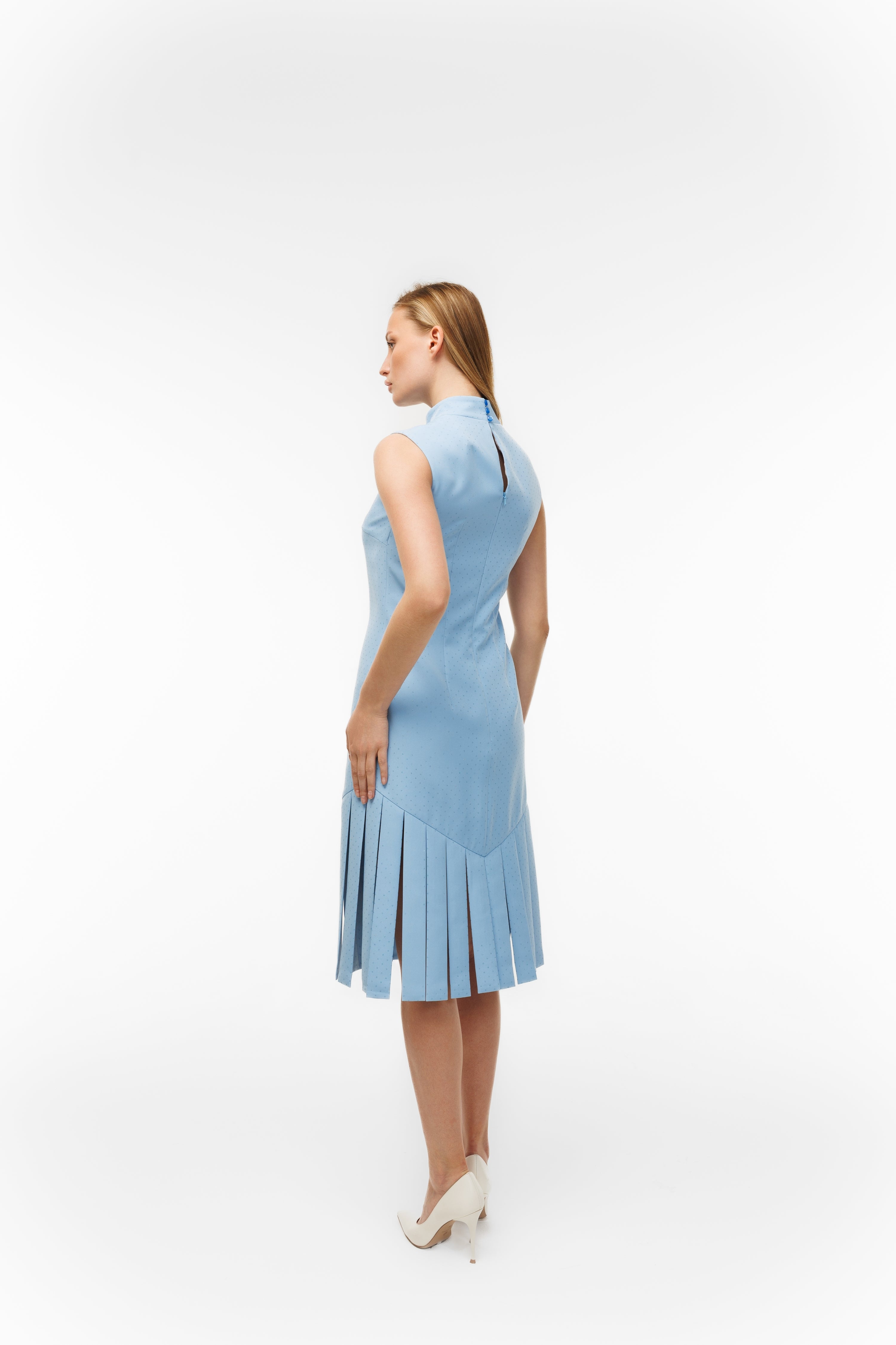 Woman wearing Charlestone Sky Blue from Mimaussy Paris, back view of light blue dress on white background, studio setting