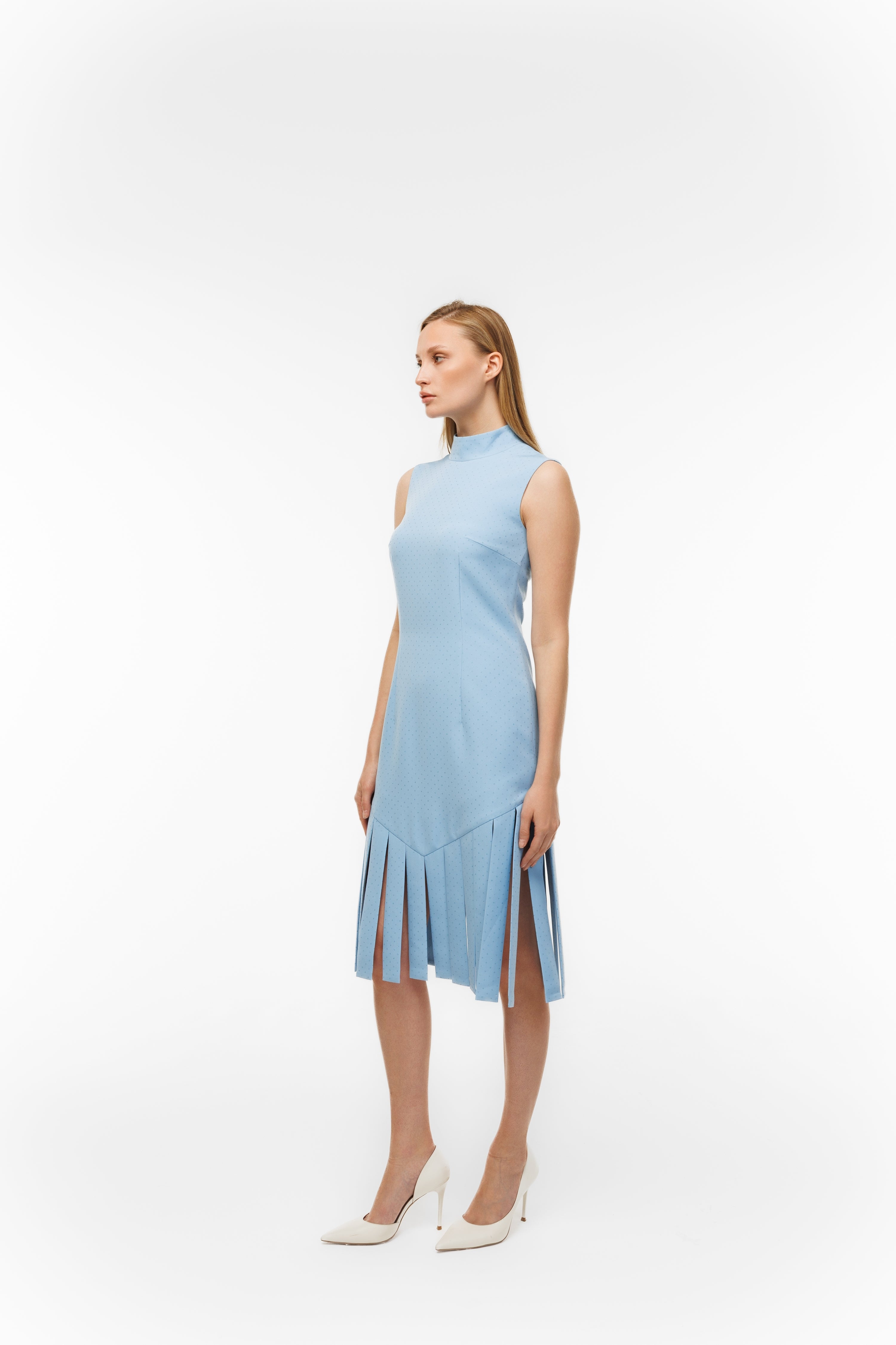 Woman wearing Charlestone Sky Blue from Mimaussy Paris, full-length side view of light blue dress on white background, studio setting