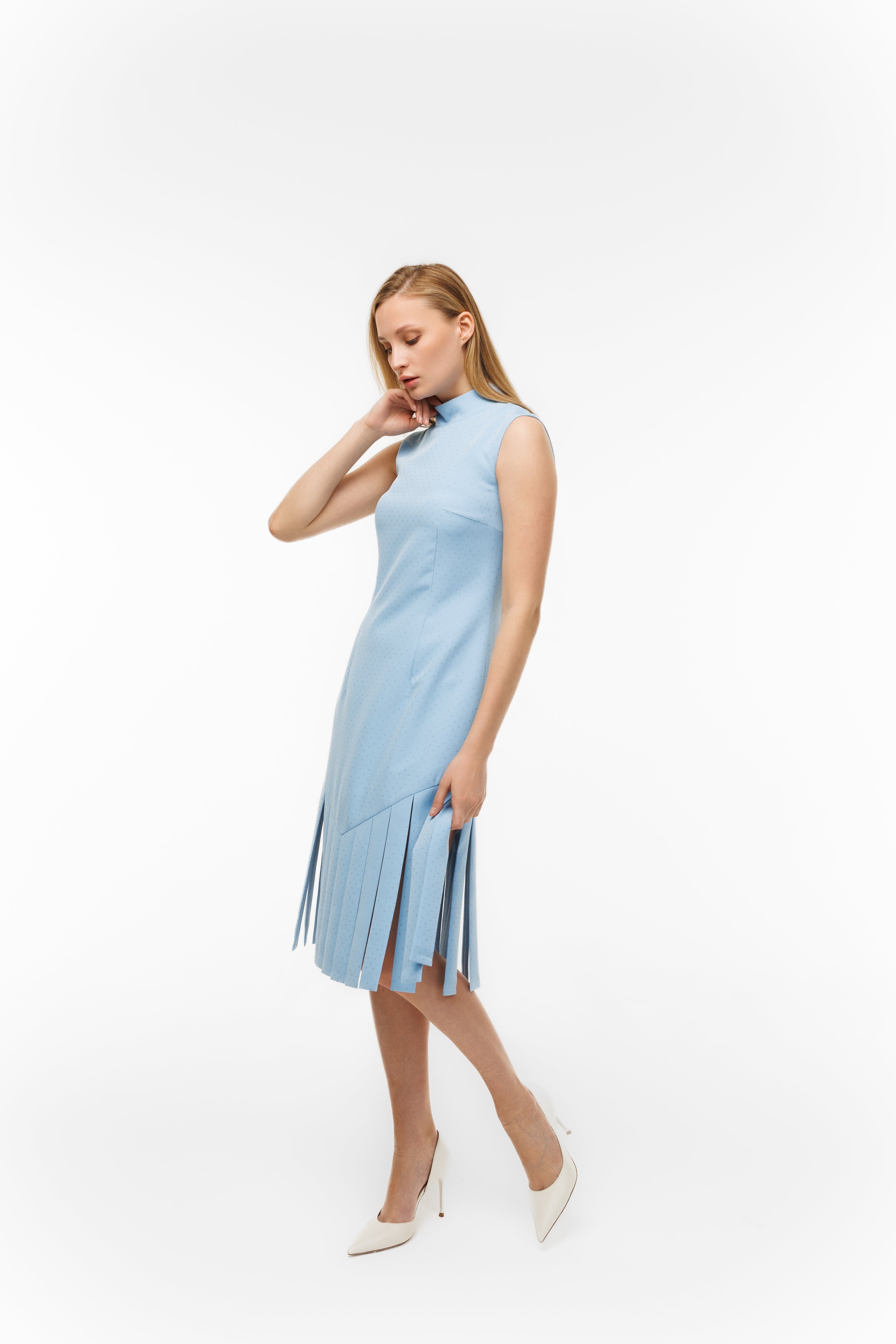 Woman wearing Charlestone Sky Blue from Mimaussy Paris, full-length view of sleeveless light blue dress with hand touching face on white background