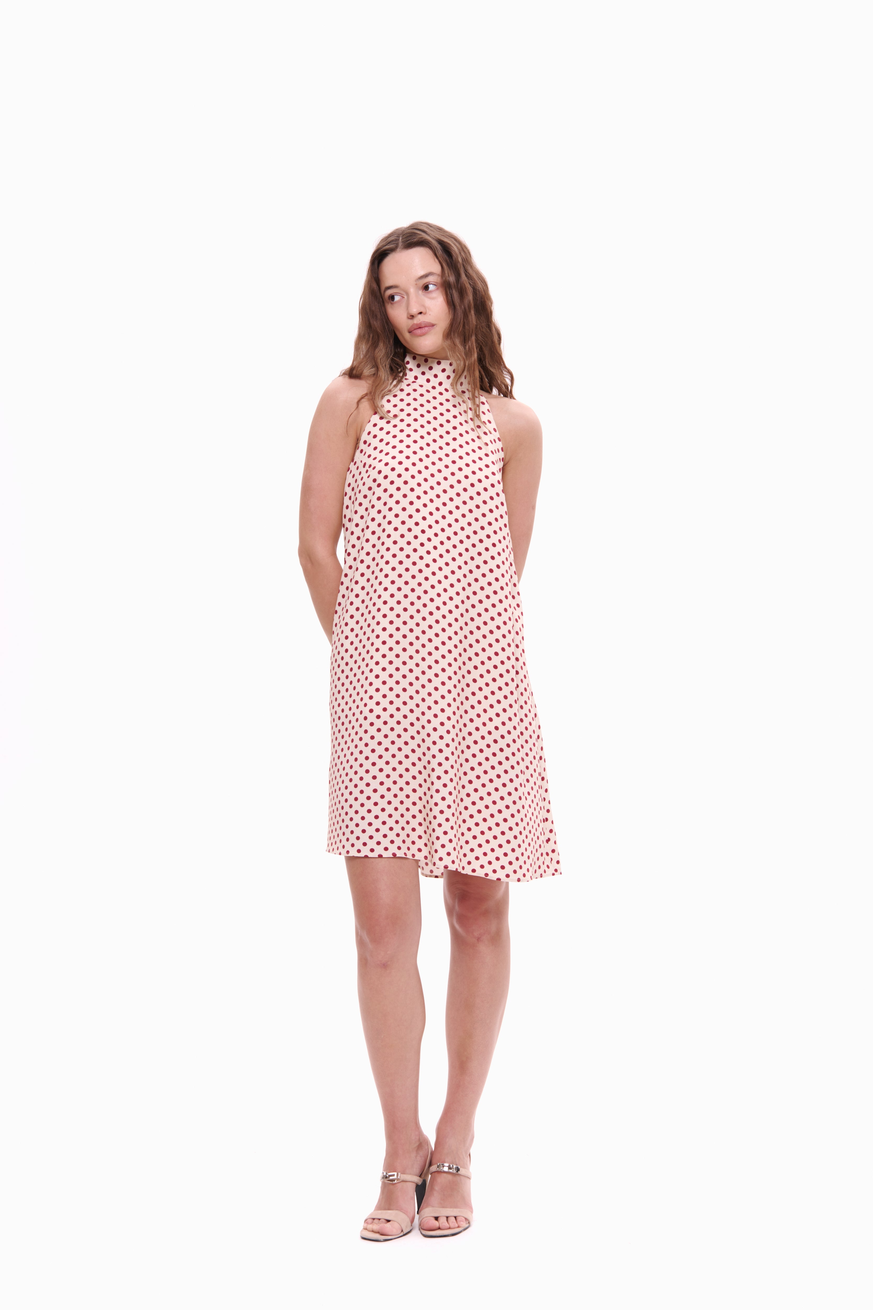 Woman wearing a pink polka dot dress on a white background