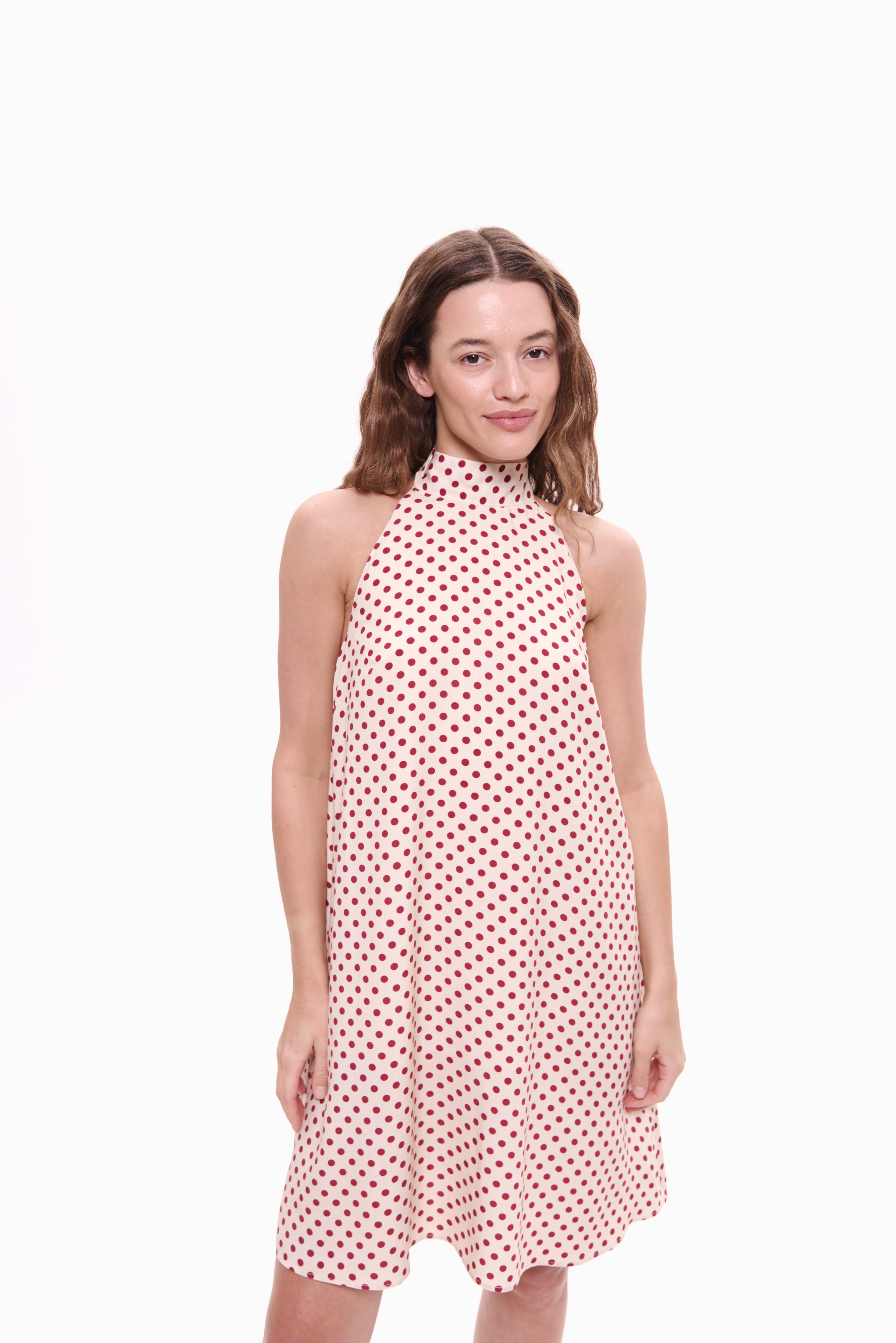 Woman wearing a red polka dot dress on a white background