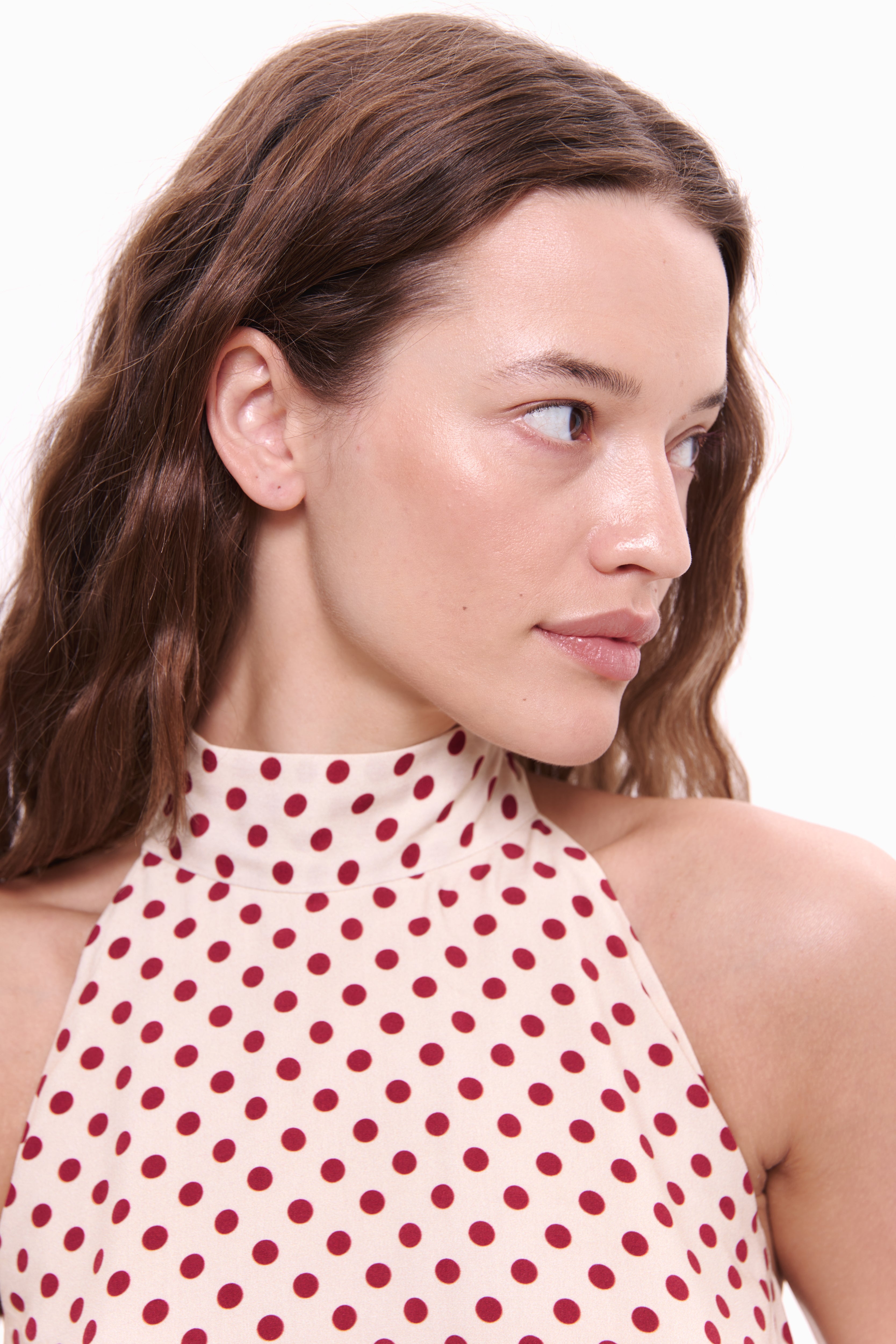 Woman wearing a red polka dot dress on a white background