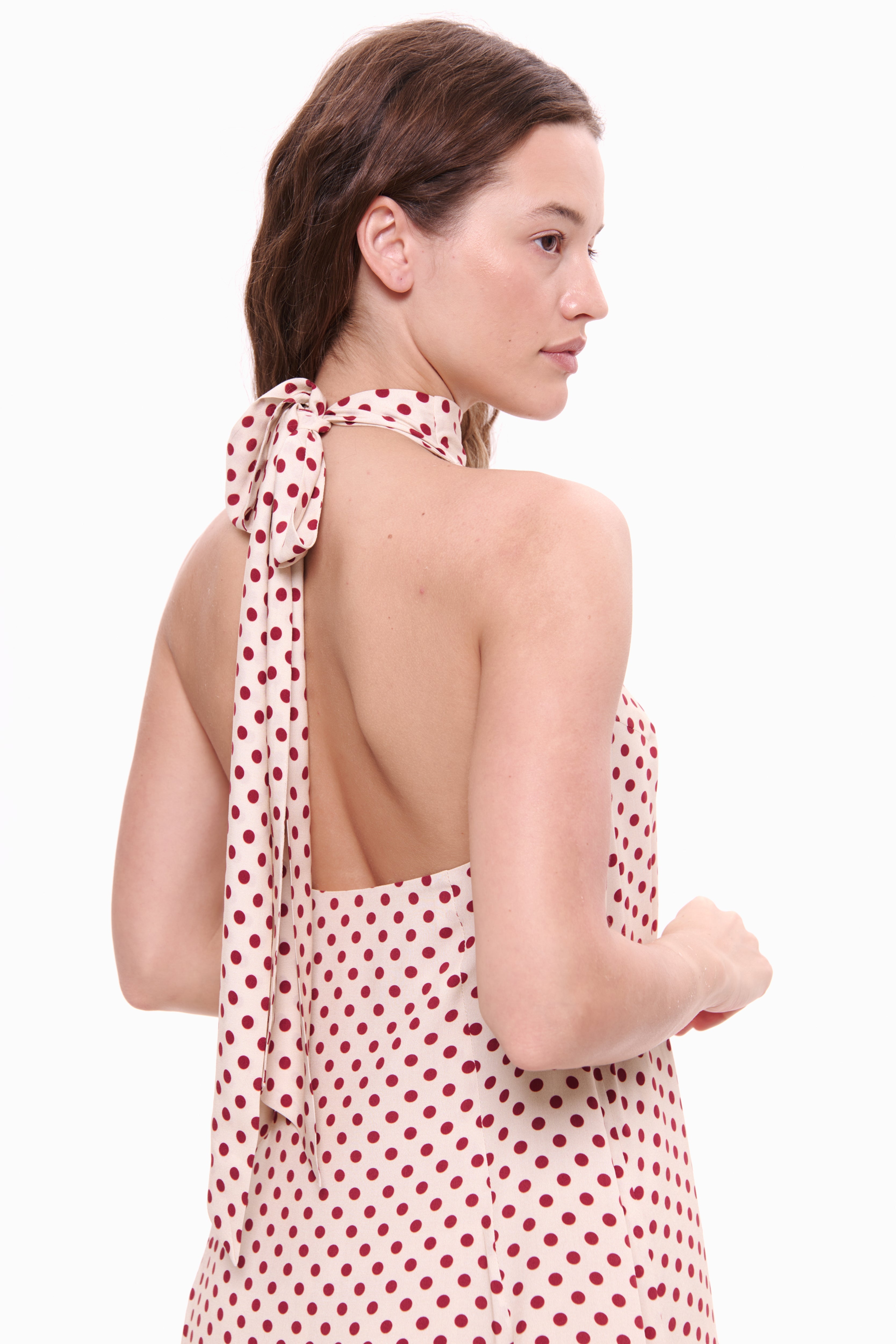 Woman wearing a red polka dot dress on a white background