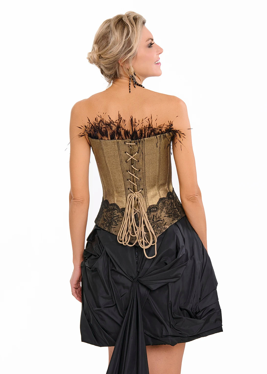 Woman wearing a steampunk-style dress with a Gold corset and black skirt from Mimaussy Paris on a white background.