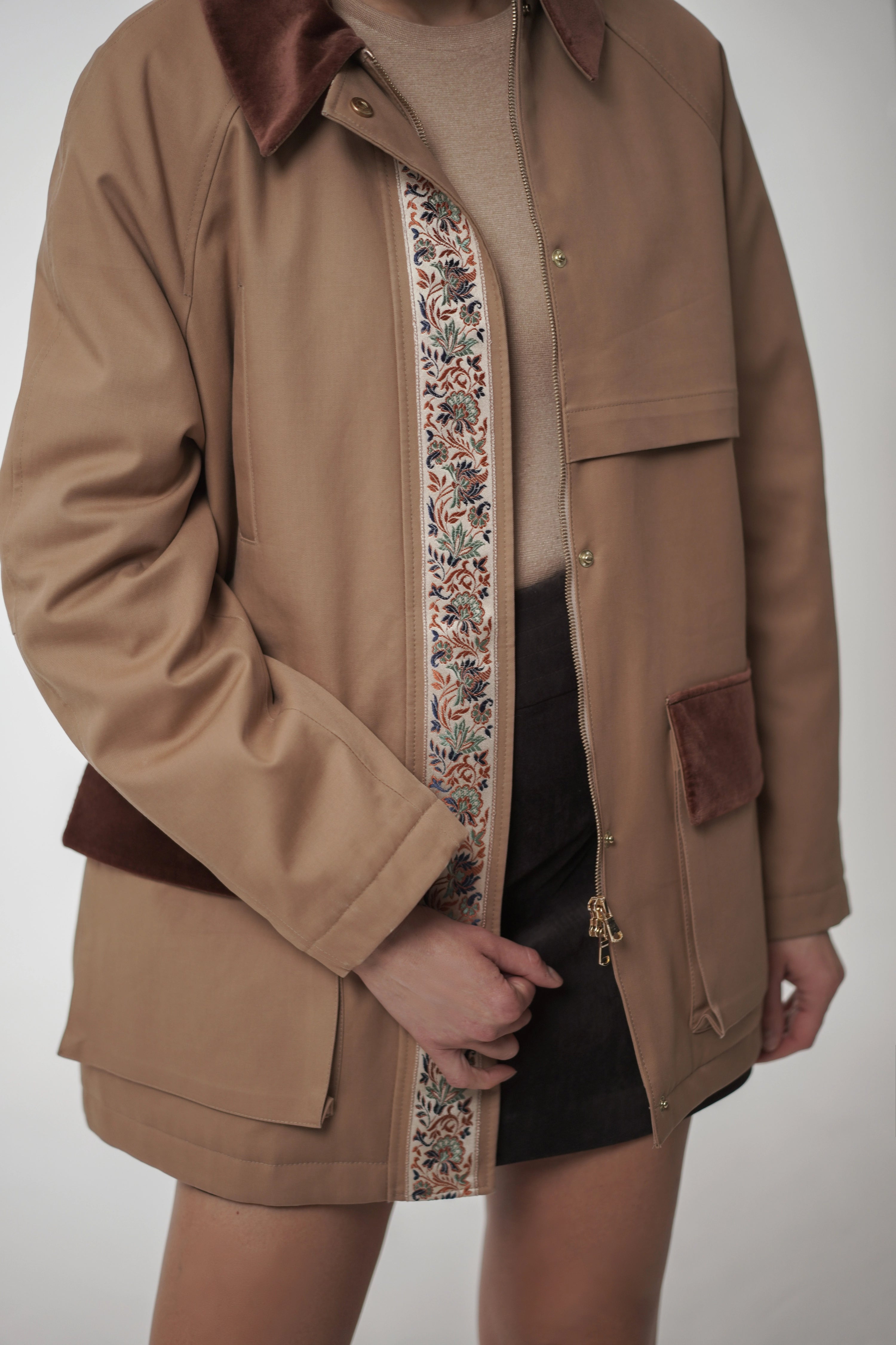 Brown coat with floral lining on a plain background