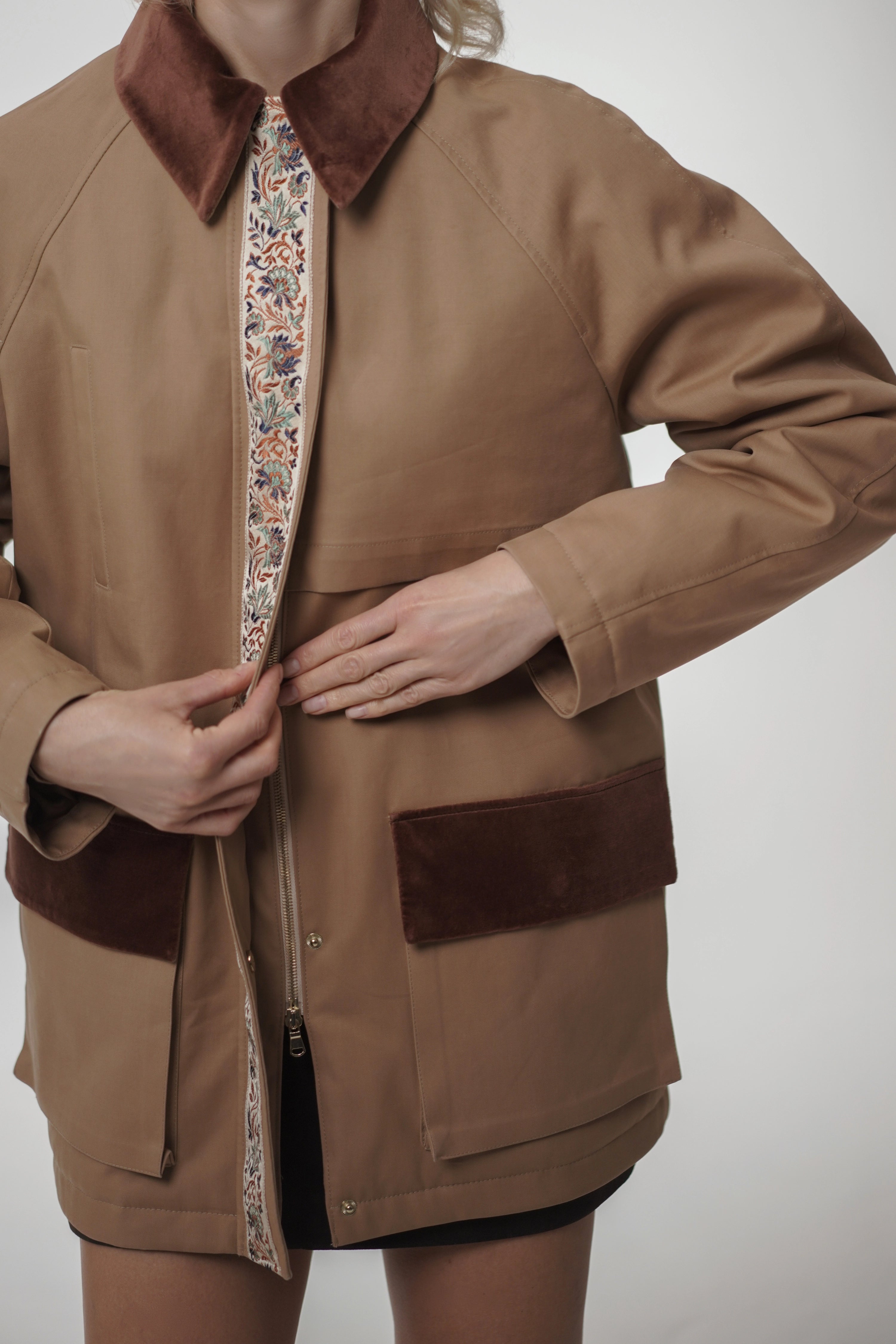 Brown jacket with floral lining and brown collar on a plain background