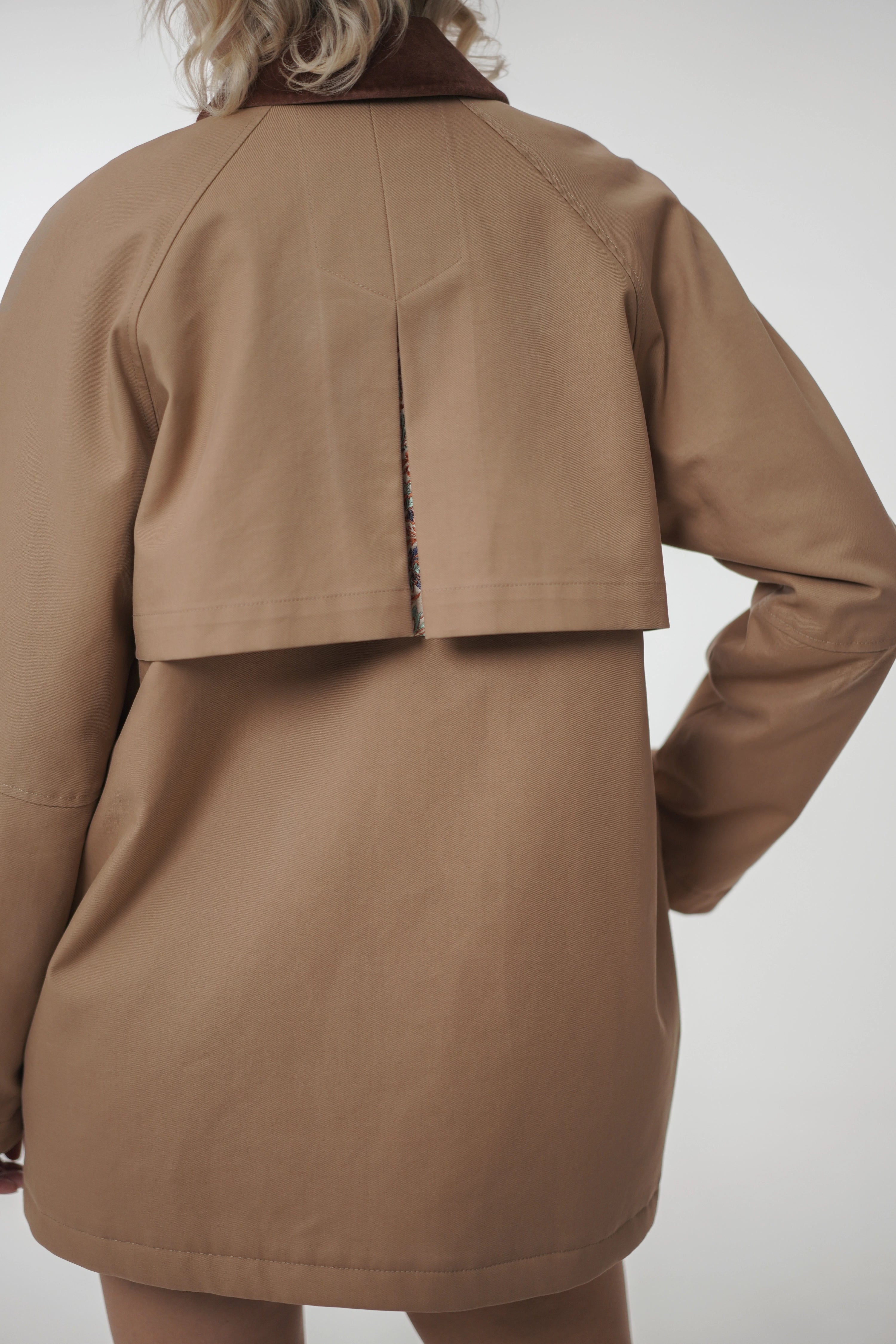 Brown coat worn by a person on a white background