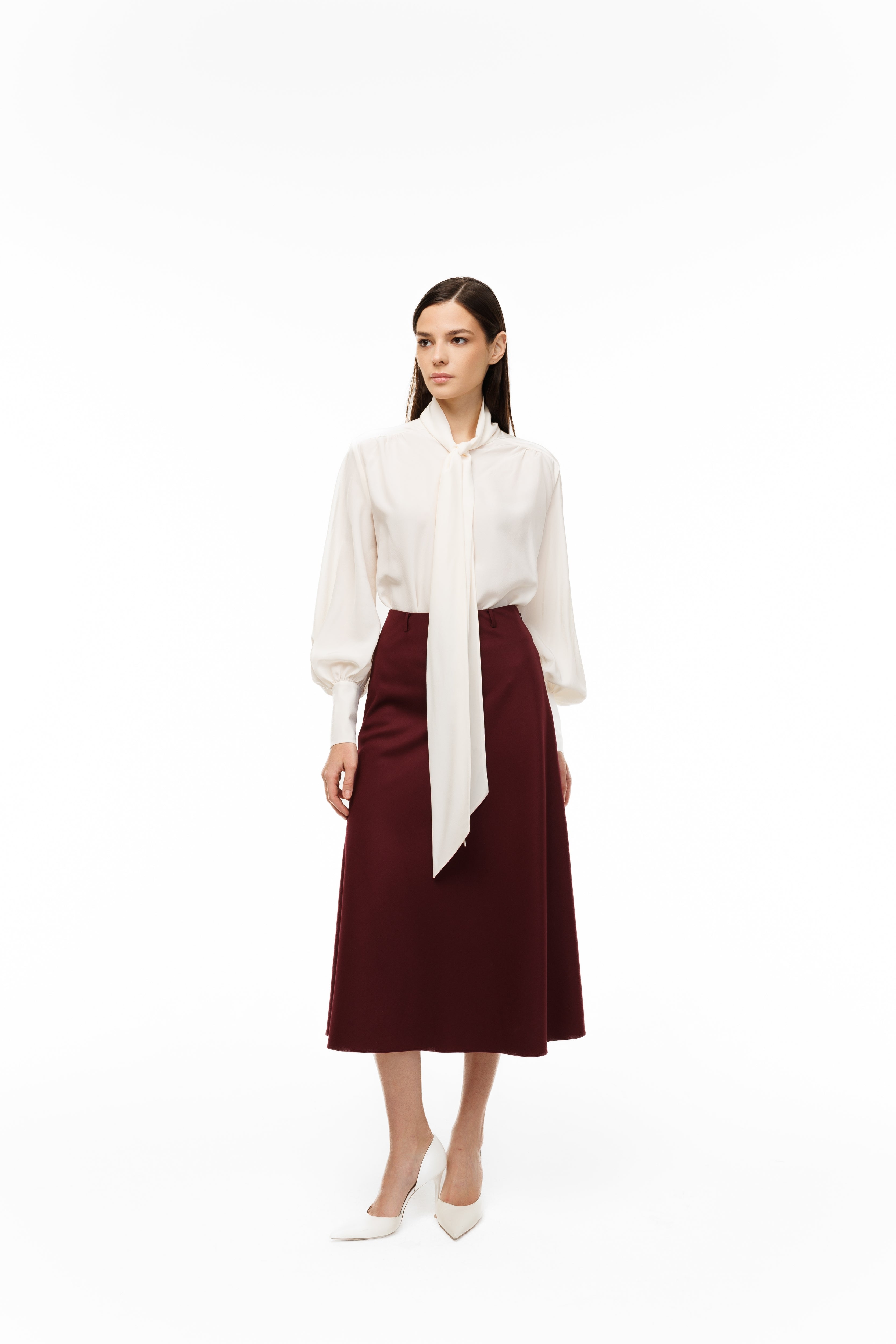 Woman wearing a white blouse and burgundy skirt on a white background