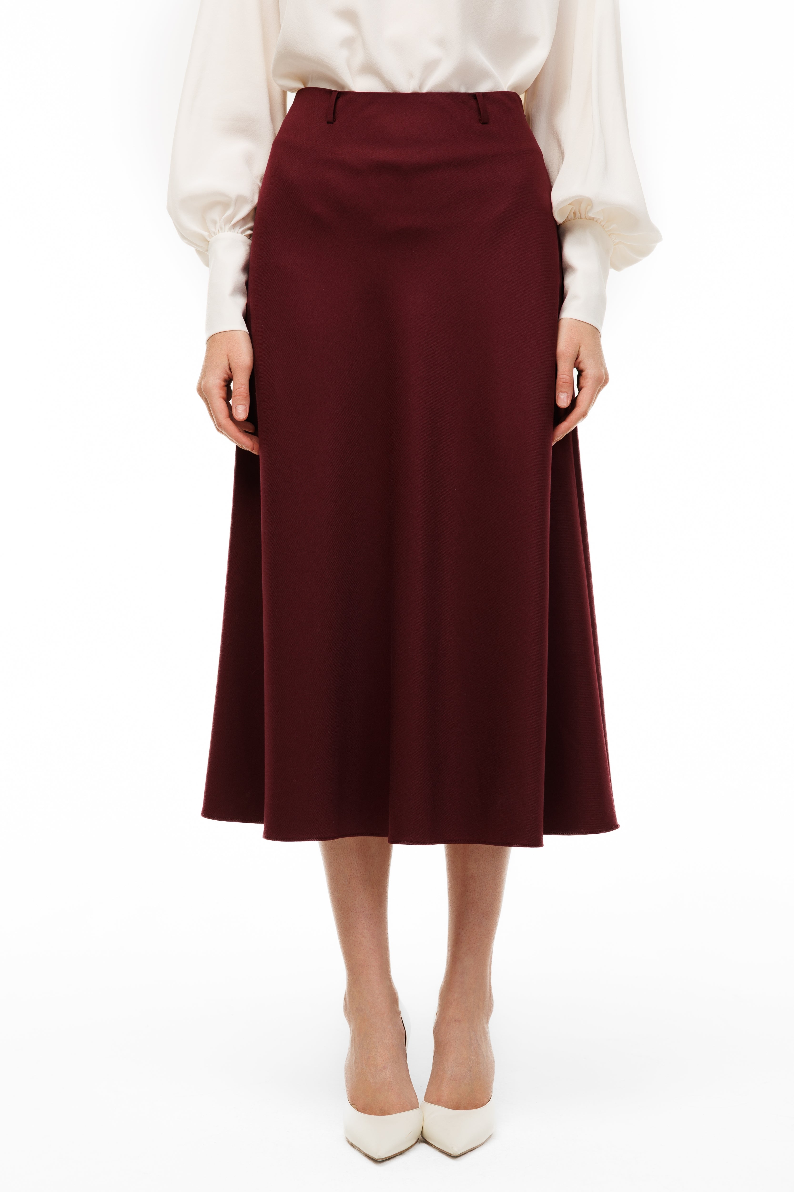 Burgundy skirt worn with a white blouse on a white background