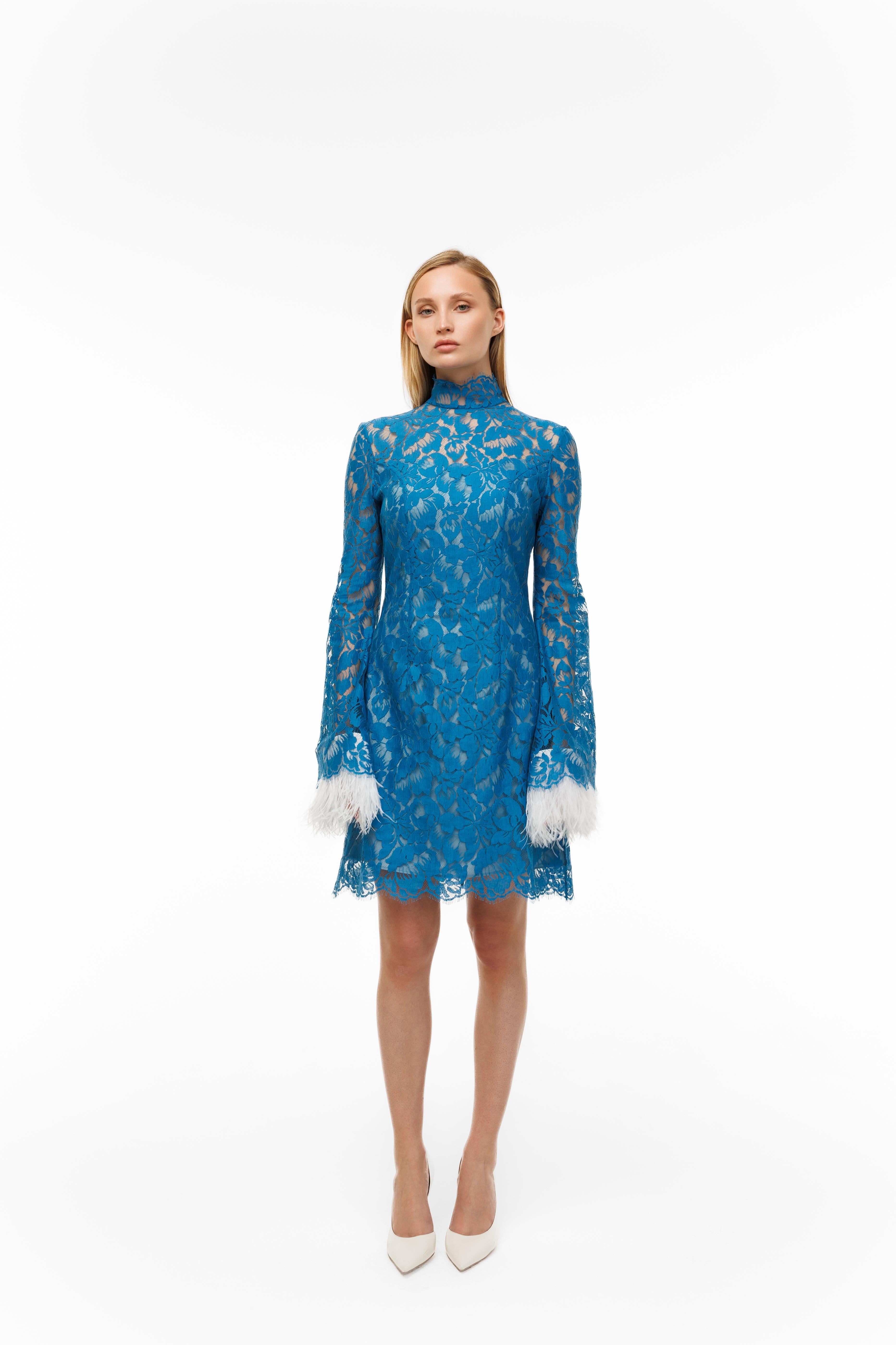 Blue lace dress with white cuffs and hem on a white background