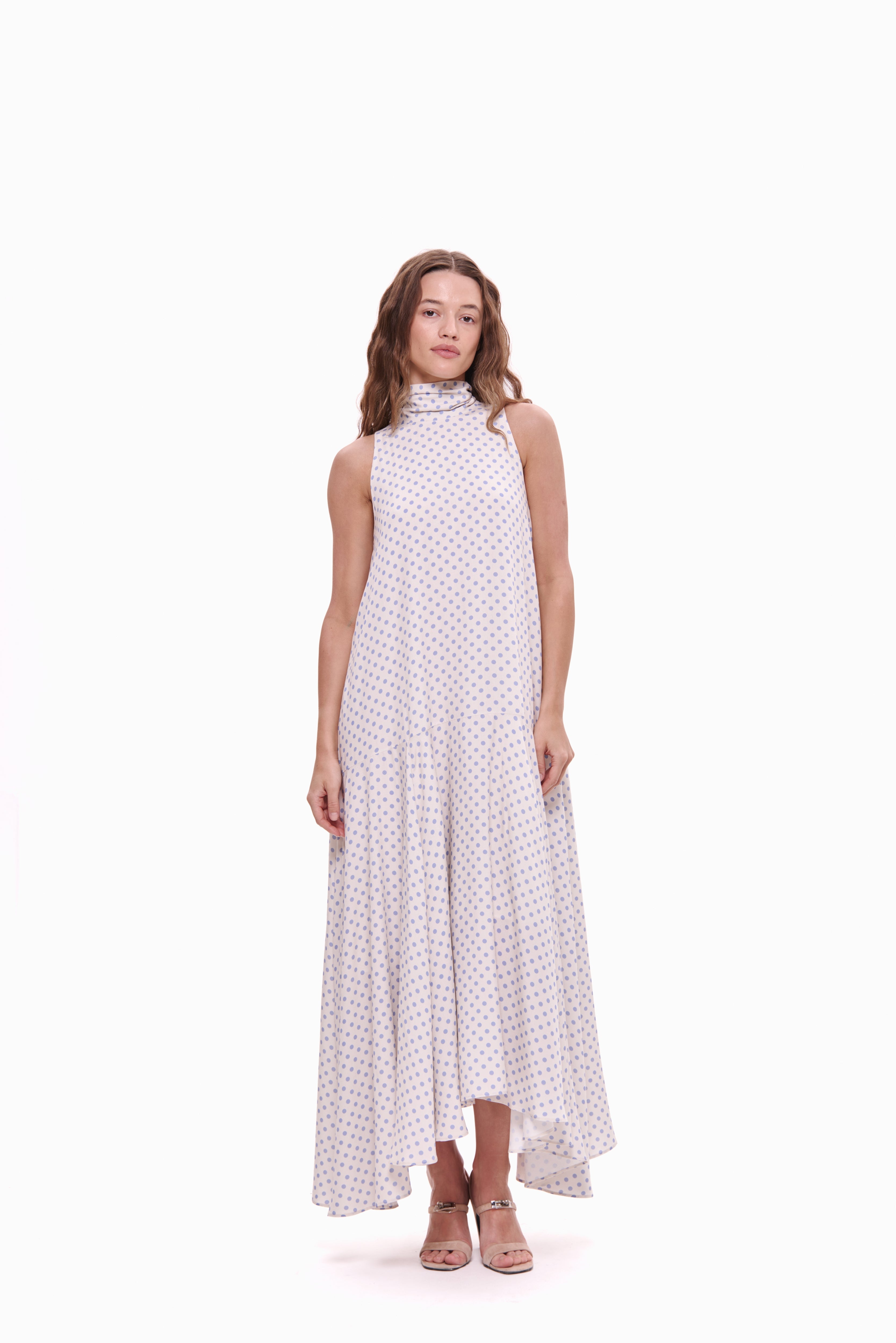 Woman wearing a white dress with lavender polka dots on a white background