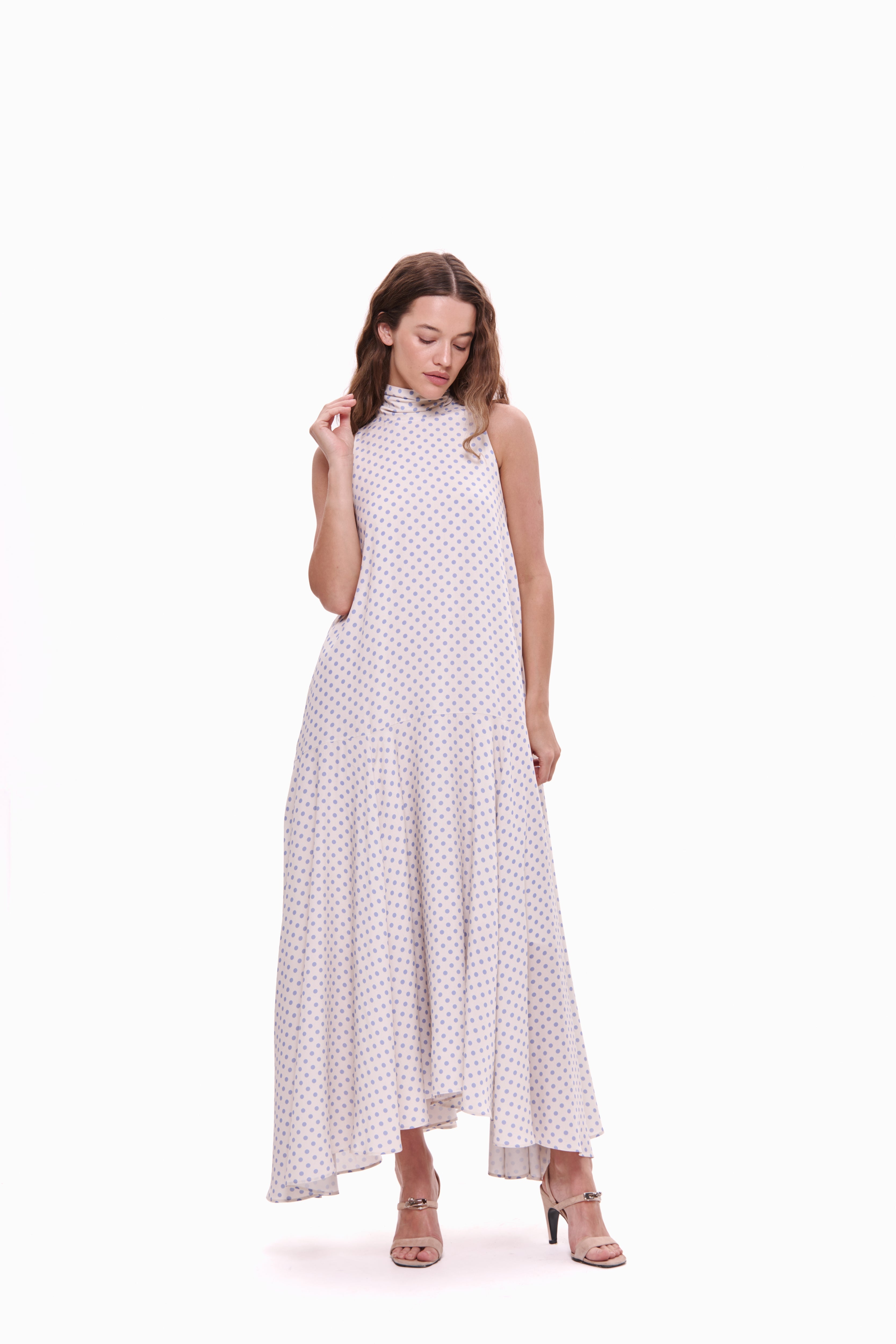 Woman wearing a white dress with black polka dots on a white background