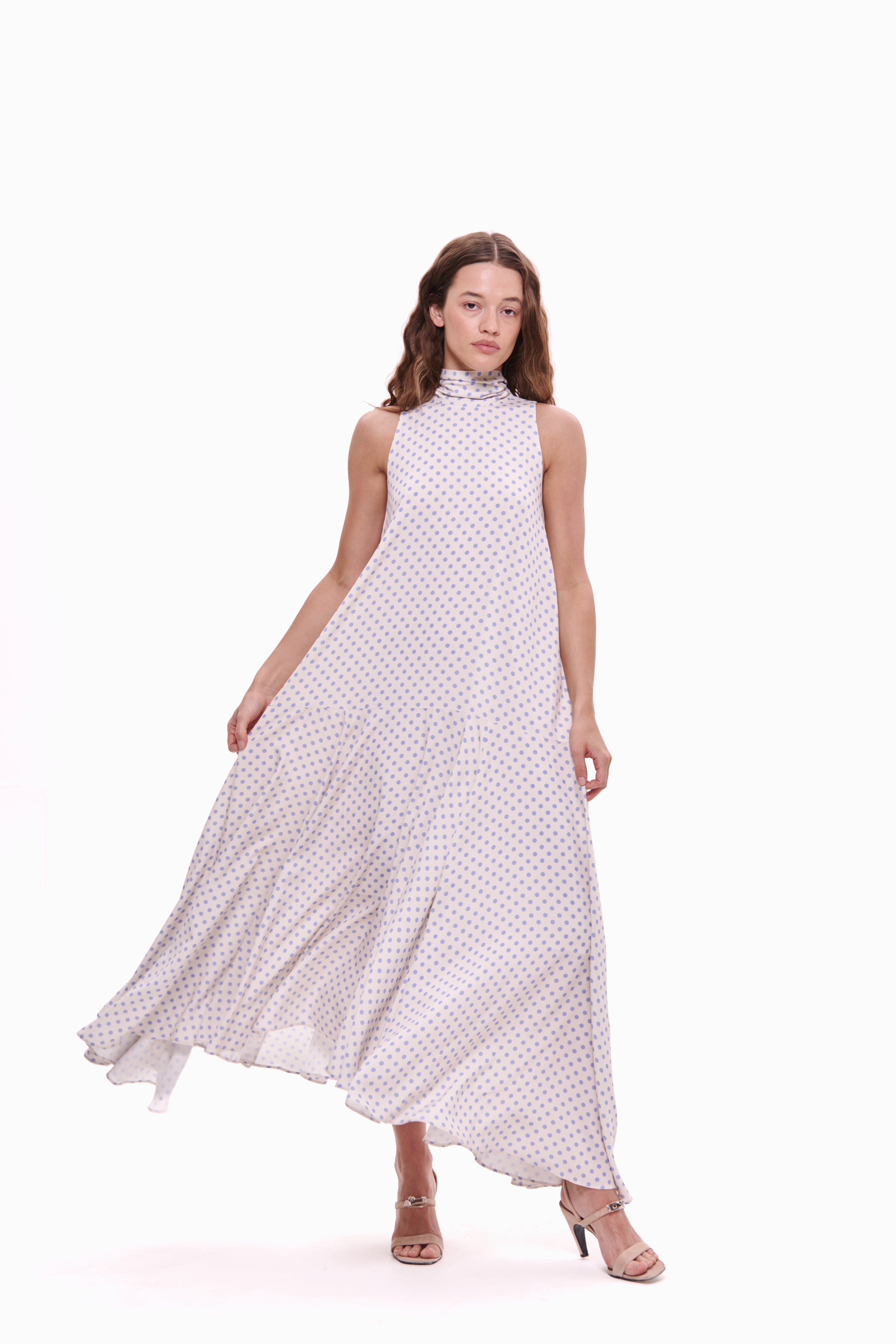 Woman wearing a white dress with black polka dots on a white background