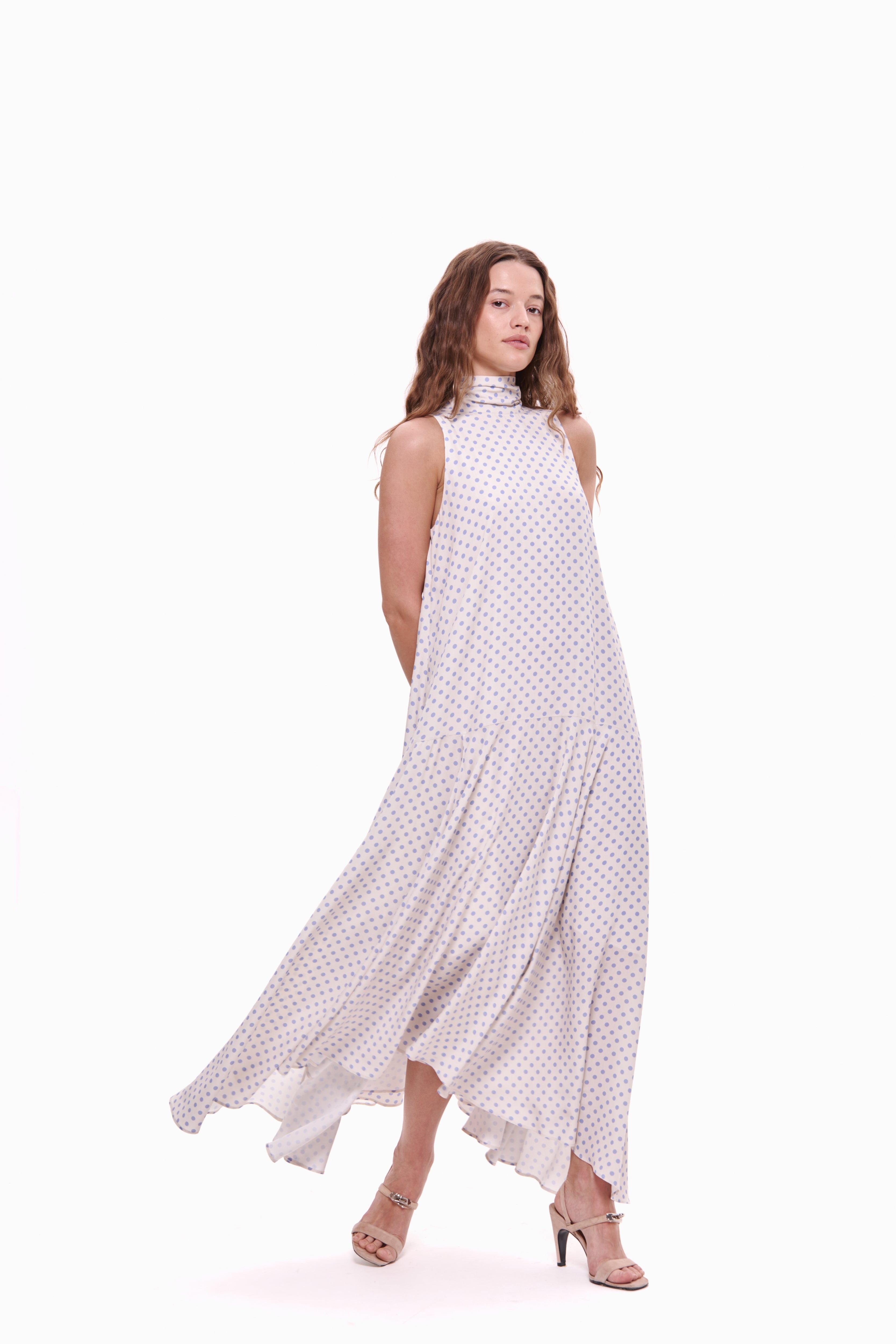 Woman wearing a white dress with black polka dots on a white background