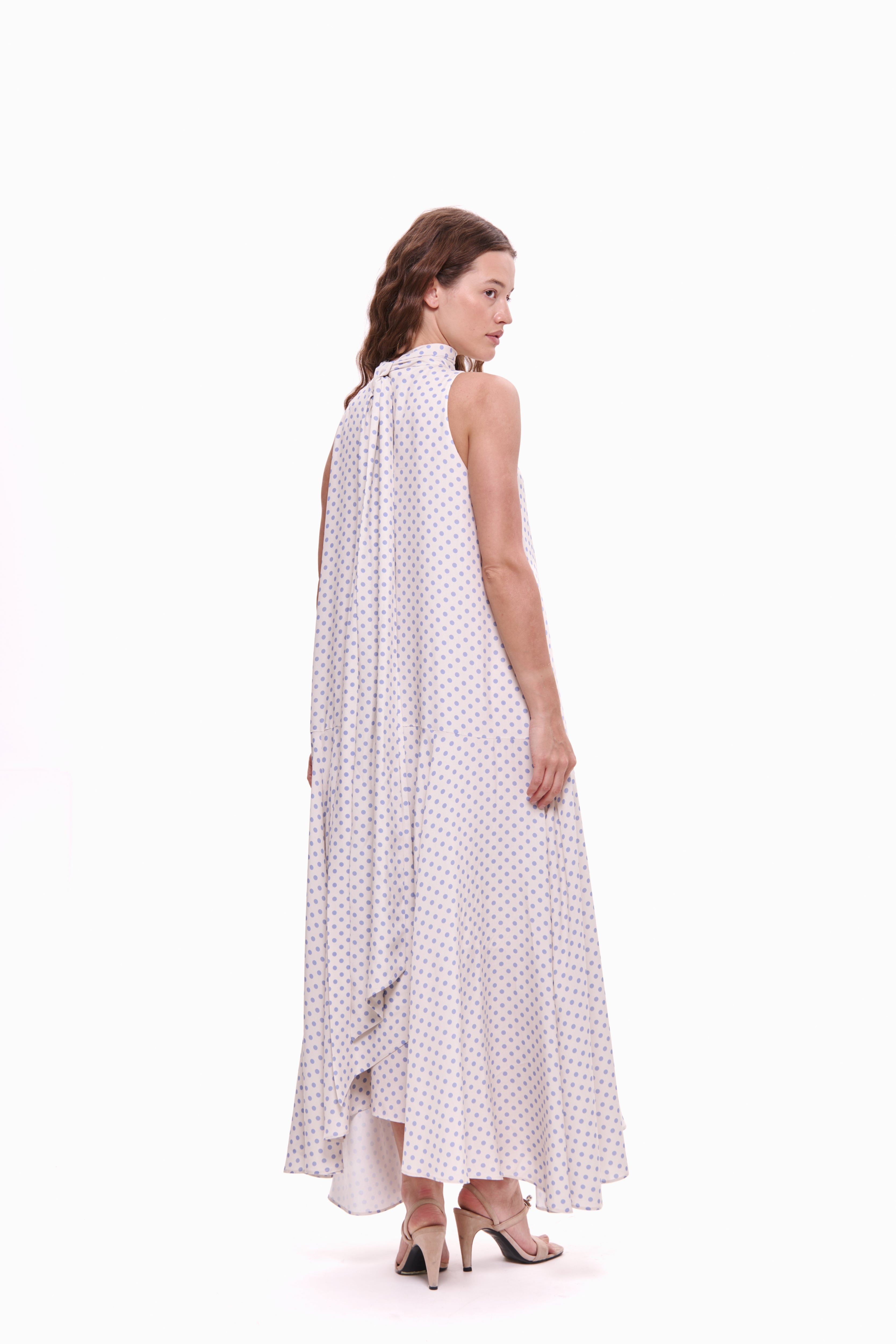 Woman wearing a white dress with black polka dots on a white background