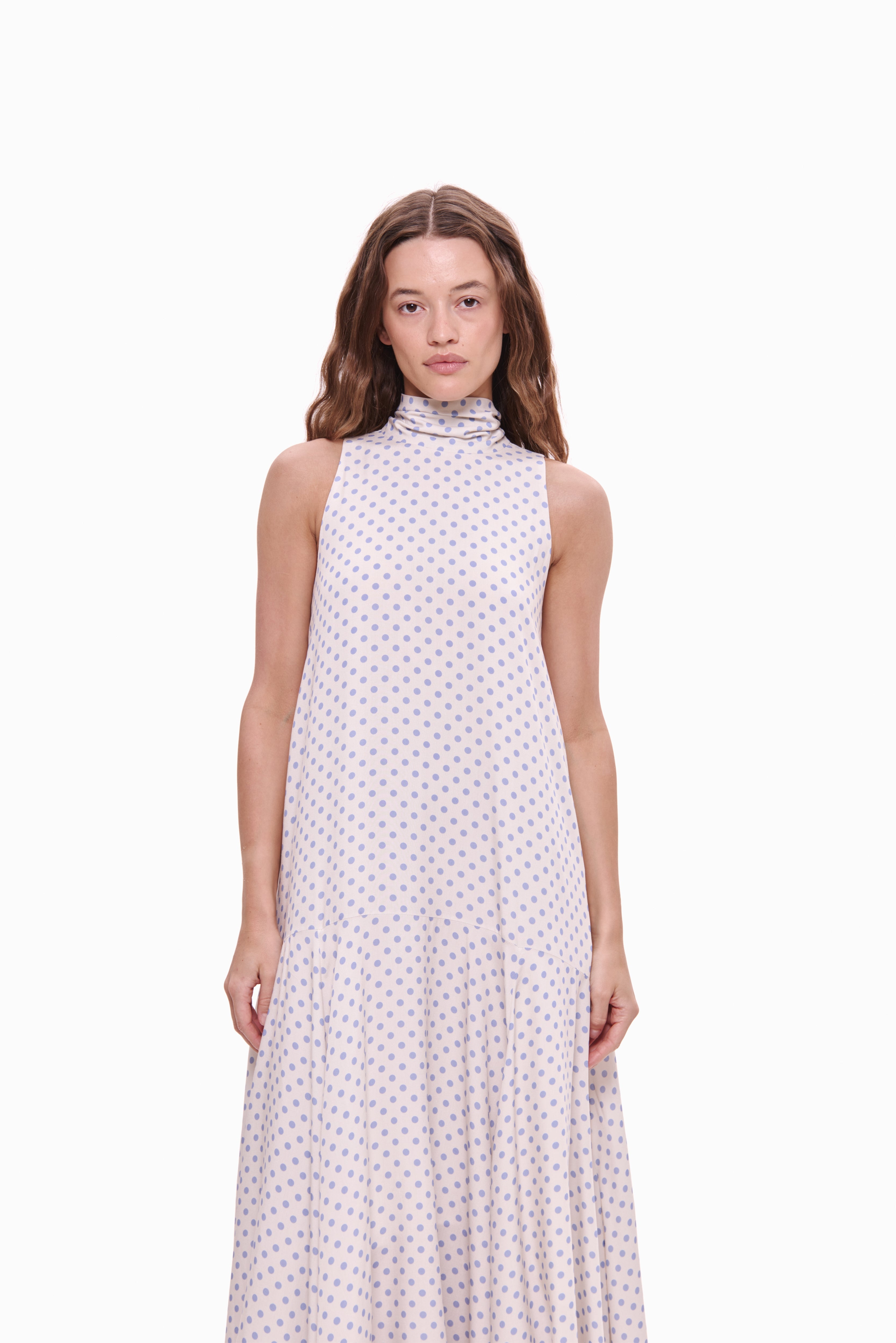 Woman wearing a sleeveless dress with a pattern on a white background