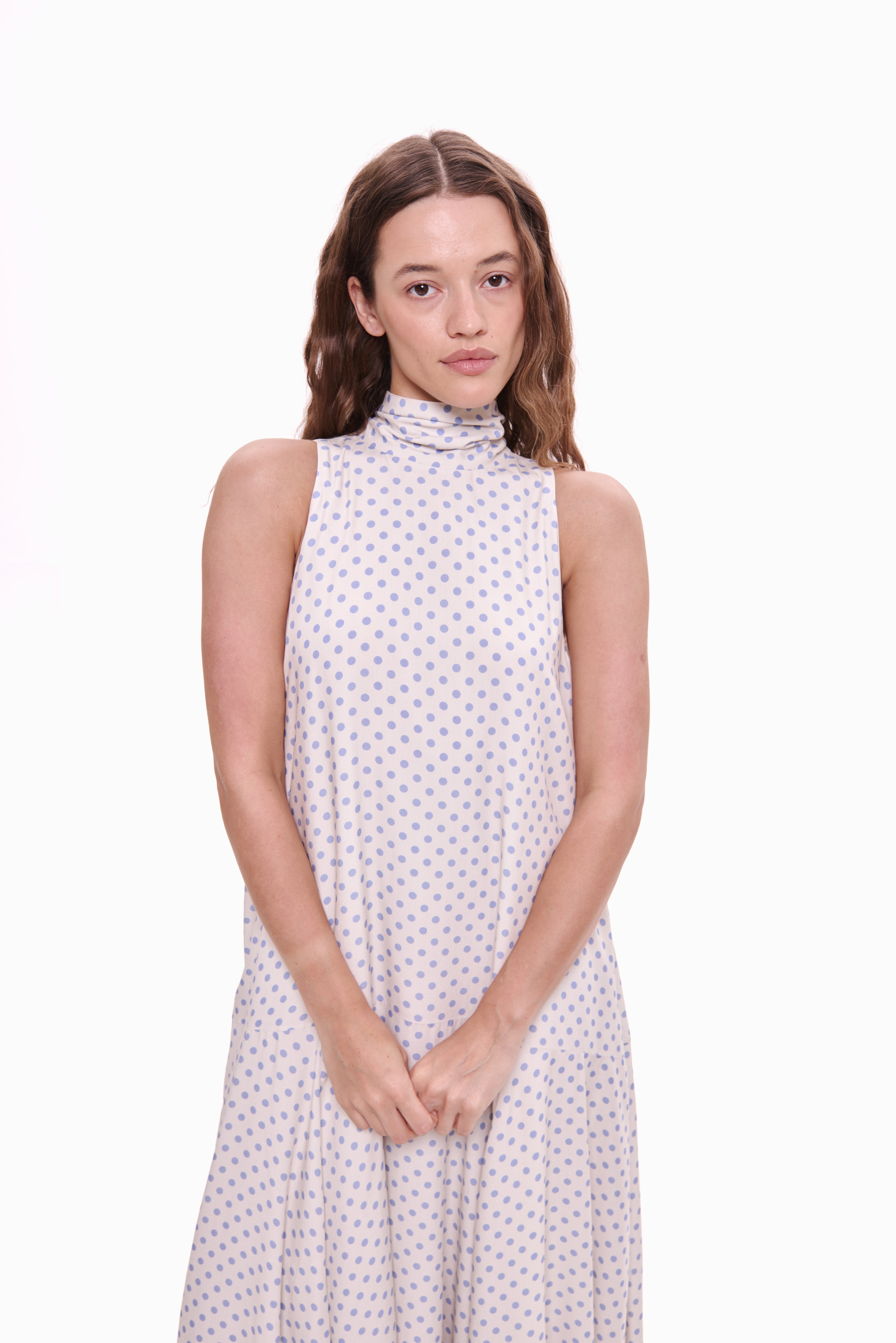 Woman wearing a sleeveless dress with a white background