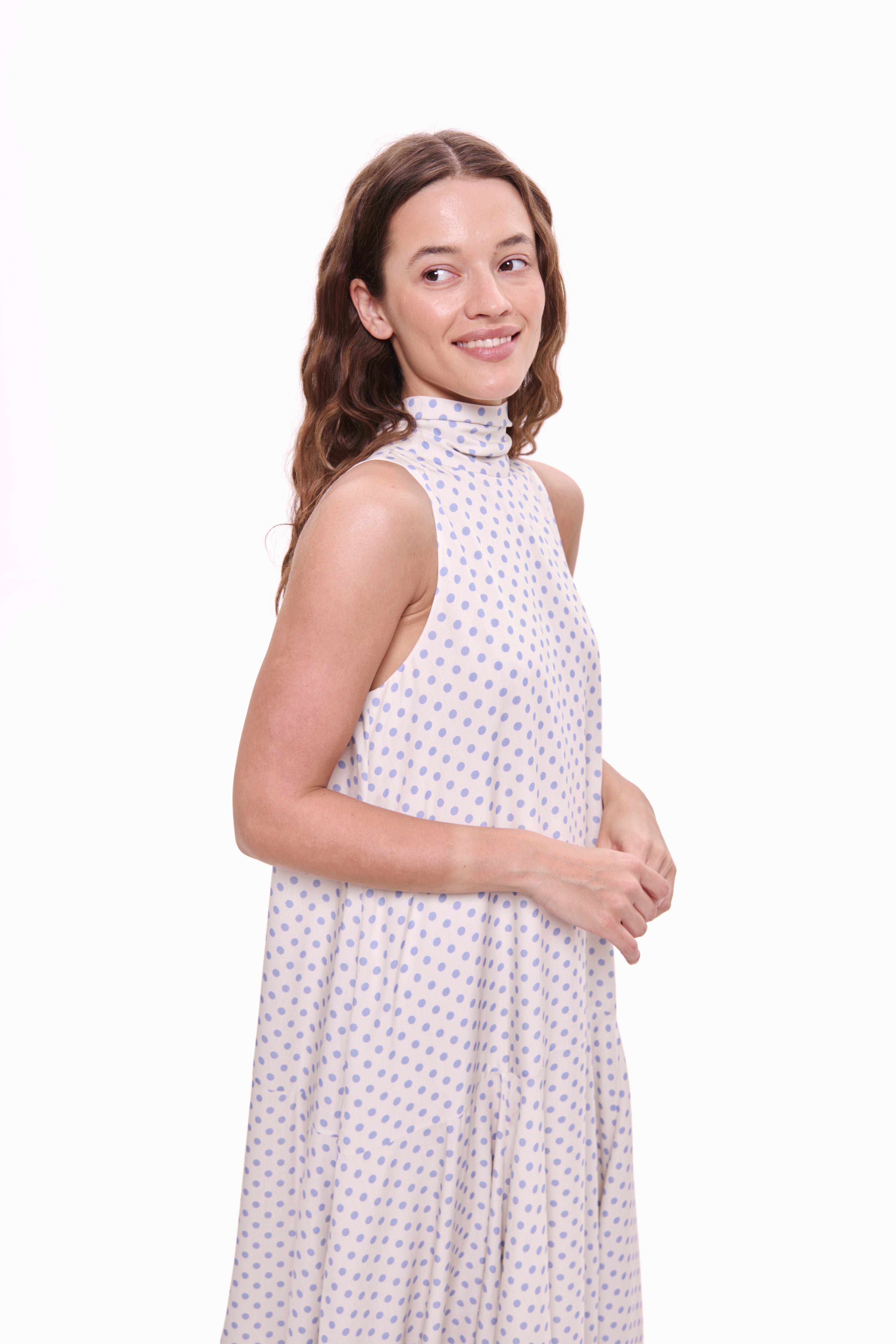 Woman wearing a white dress with a subtle pattern on a white background