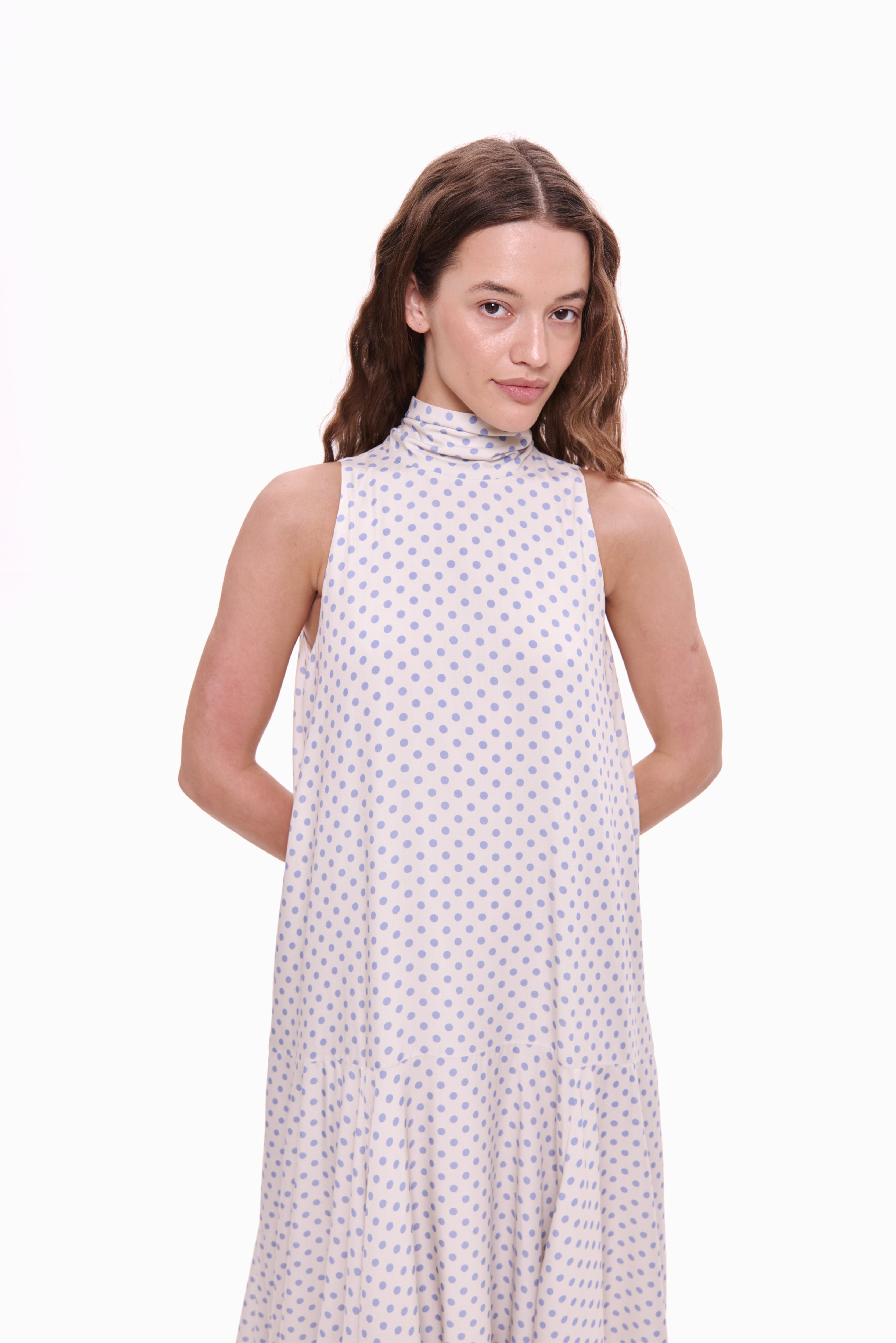 Woman wearing a sleeveless dress with a white background