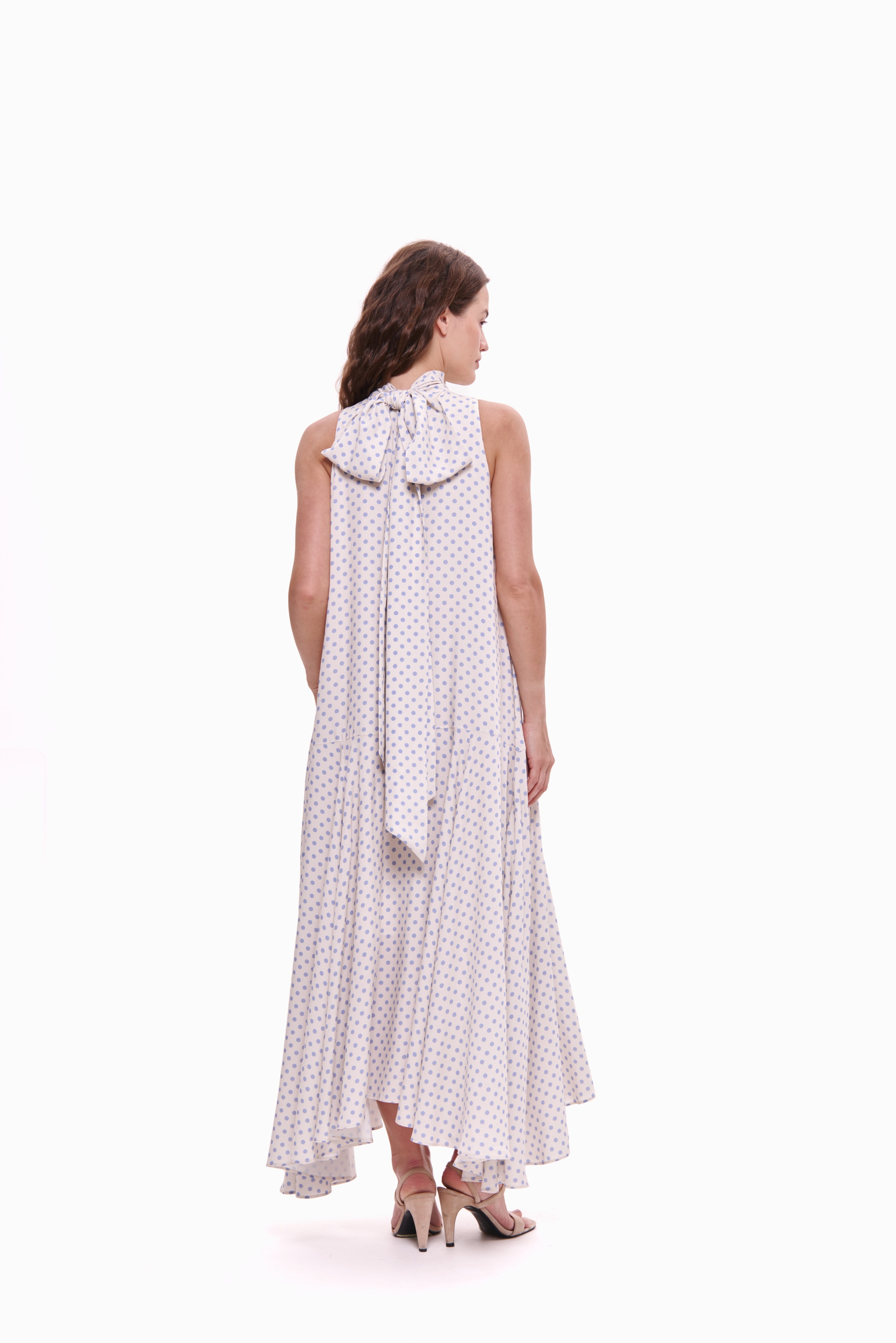 Woman wearing a white dress with black polka dots on a white background