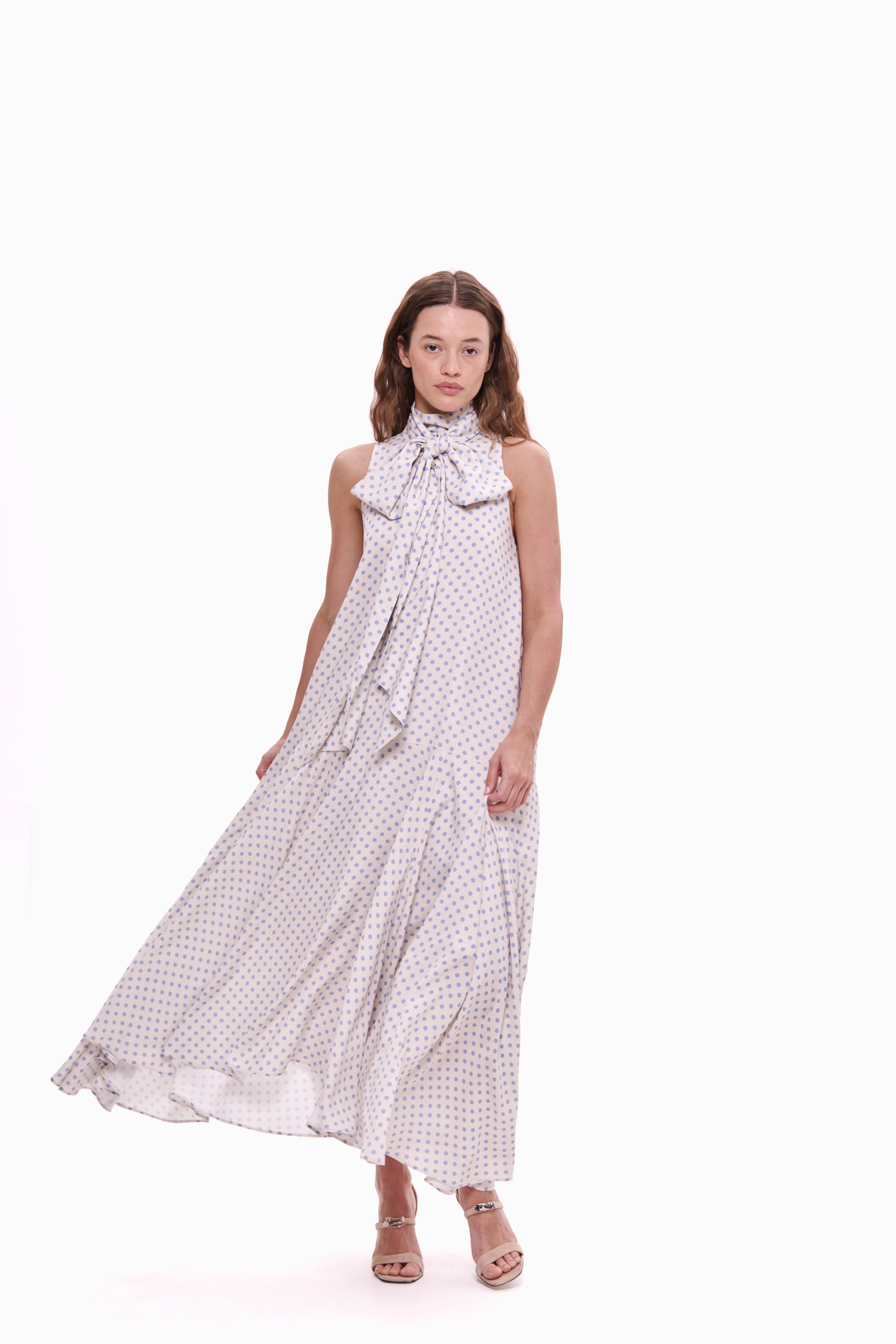 Woman wearing a long, patterned dress on a white background