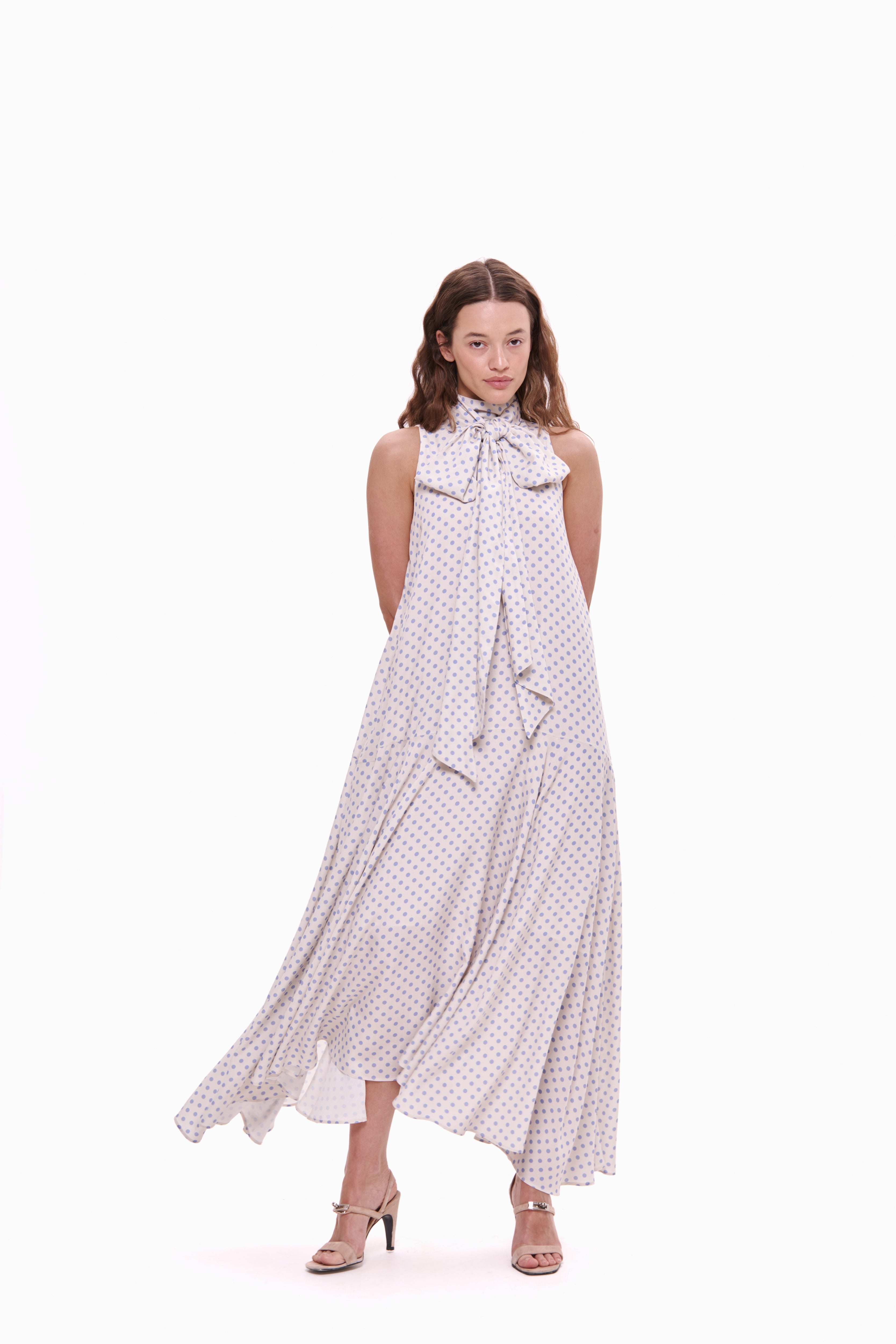 Woman wearing a long, patterned dress on a white background