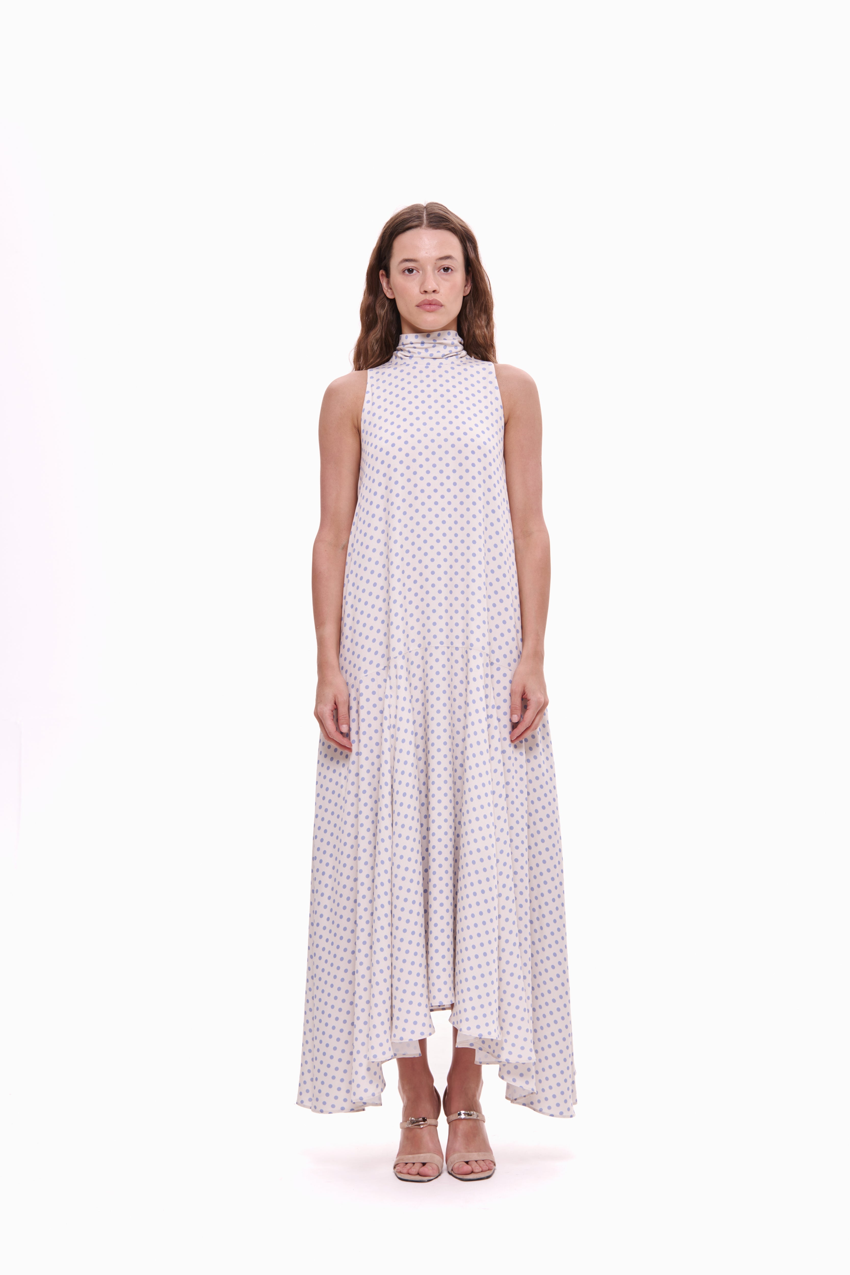 Woman wearing a white dress with lavender polka dots on a white background