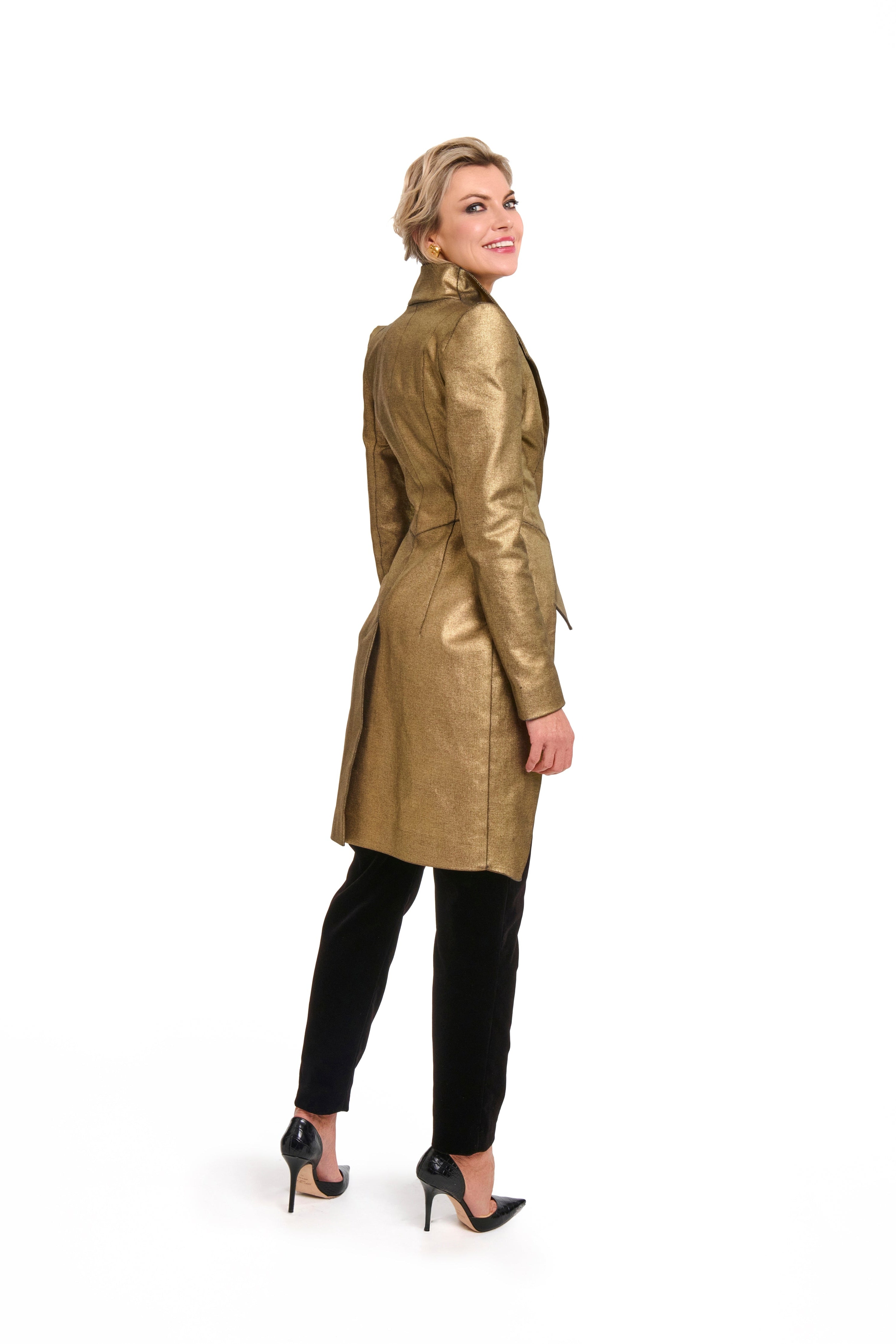 Woman wearing a Longline Gold Jacket from Mimaussy Paris, gold trench coat, on a white background