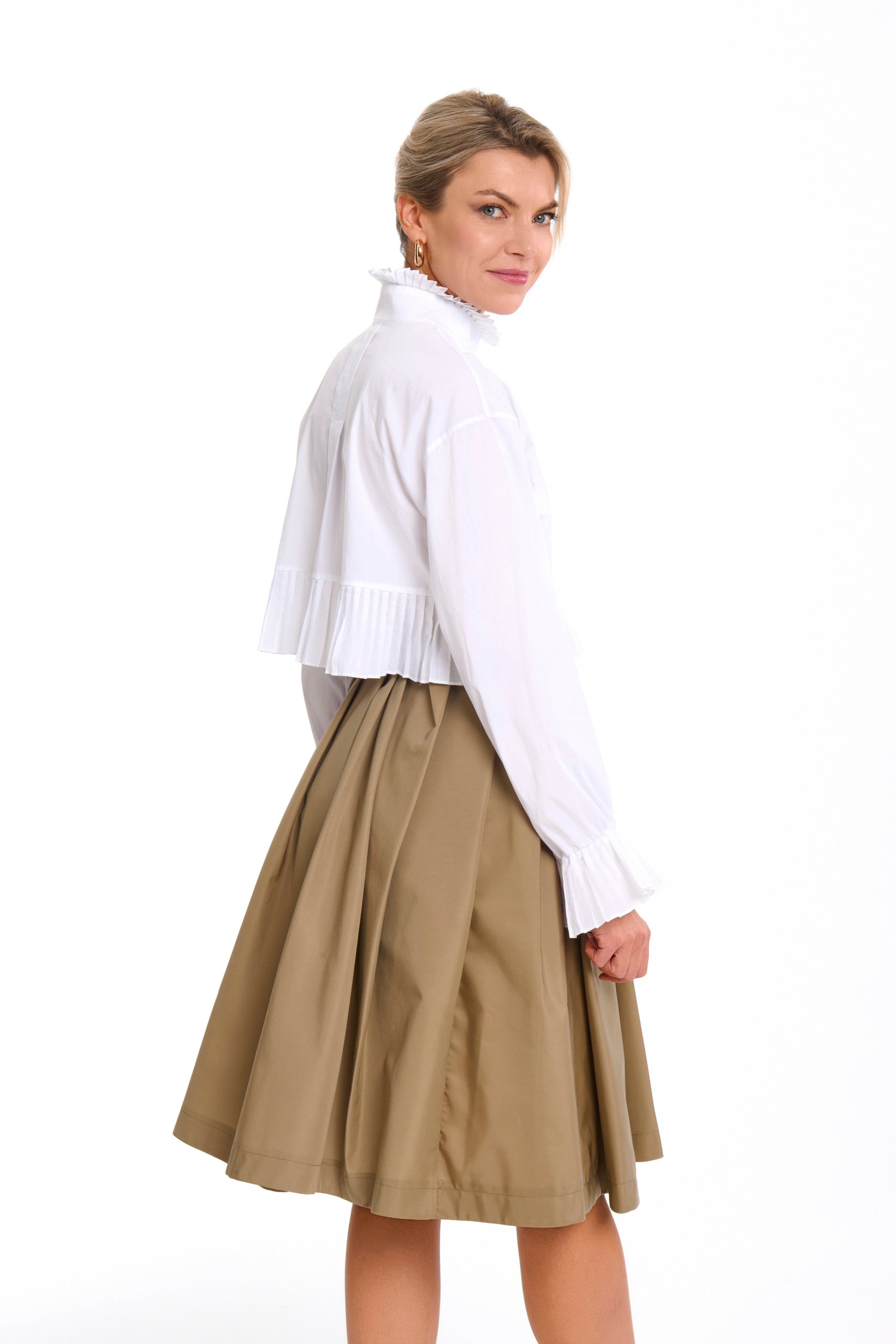 Woman wearing a Mademoiselle Plissé cropped shirt-blouse from Mimaussy Paris, beige skirt, on a white background