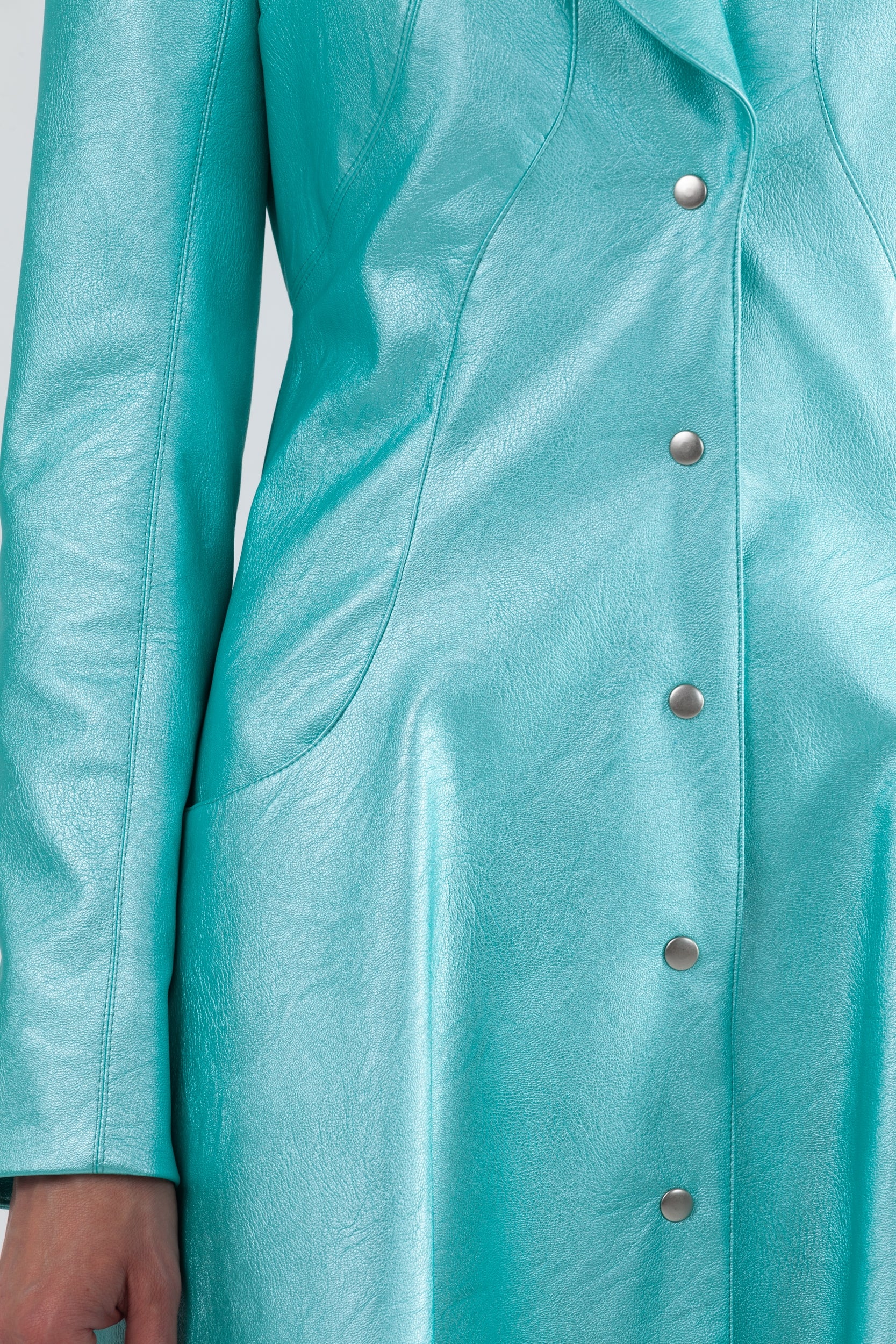 Woman wearing Matrix Coat from Mimaussy Paris in Tiffany Blue, studio close-up of midsection and sleeve details against a plain white background