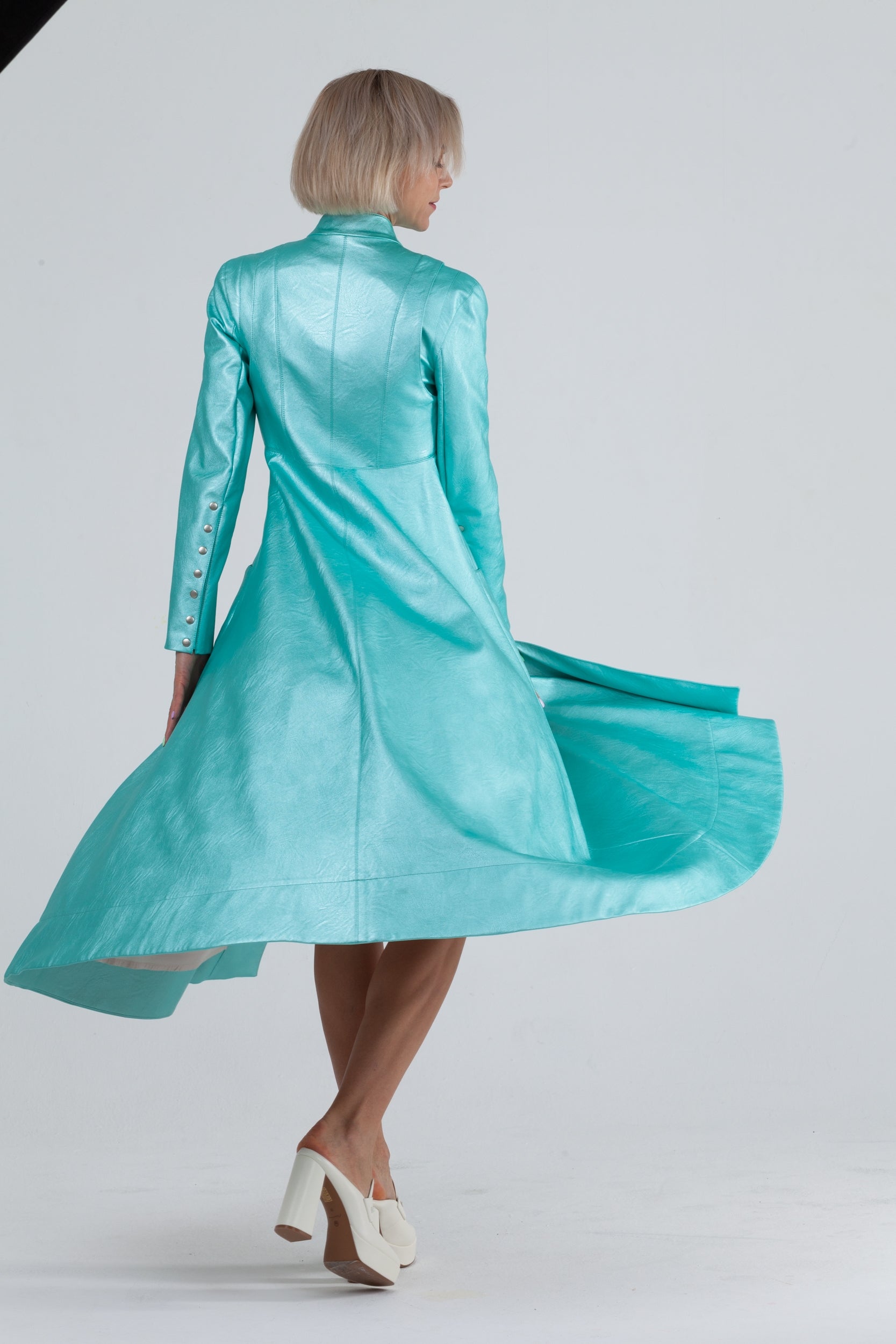 Woman wearing Matrix Coat from Mimaussy Paris in Tiffany Blue, long sleeves and high collar, front view against a plain white background