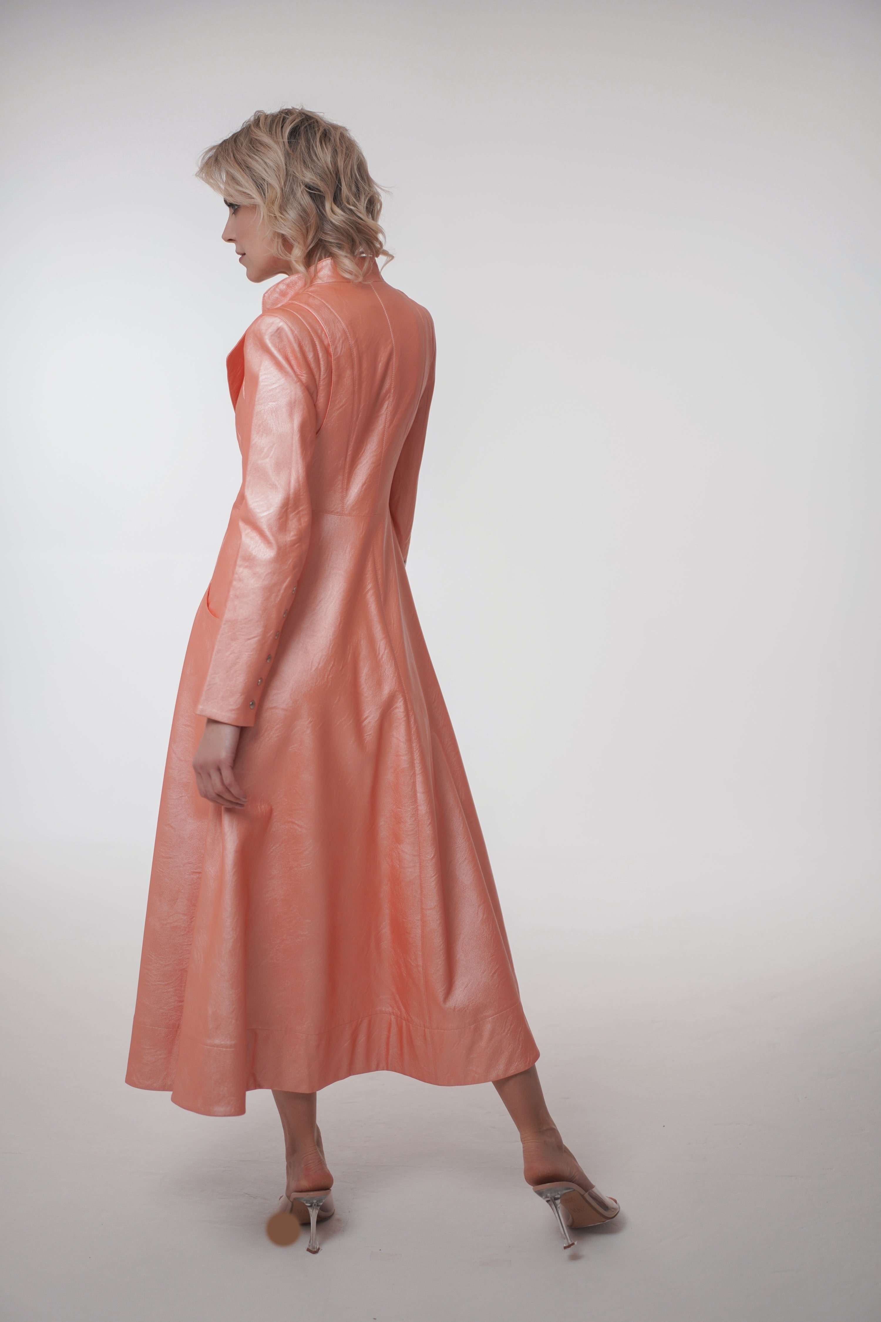 Woman wearing Matrix Coat from Mimaussy Paris in light pink, back view full-length shot in studio setting against a plain white background