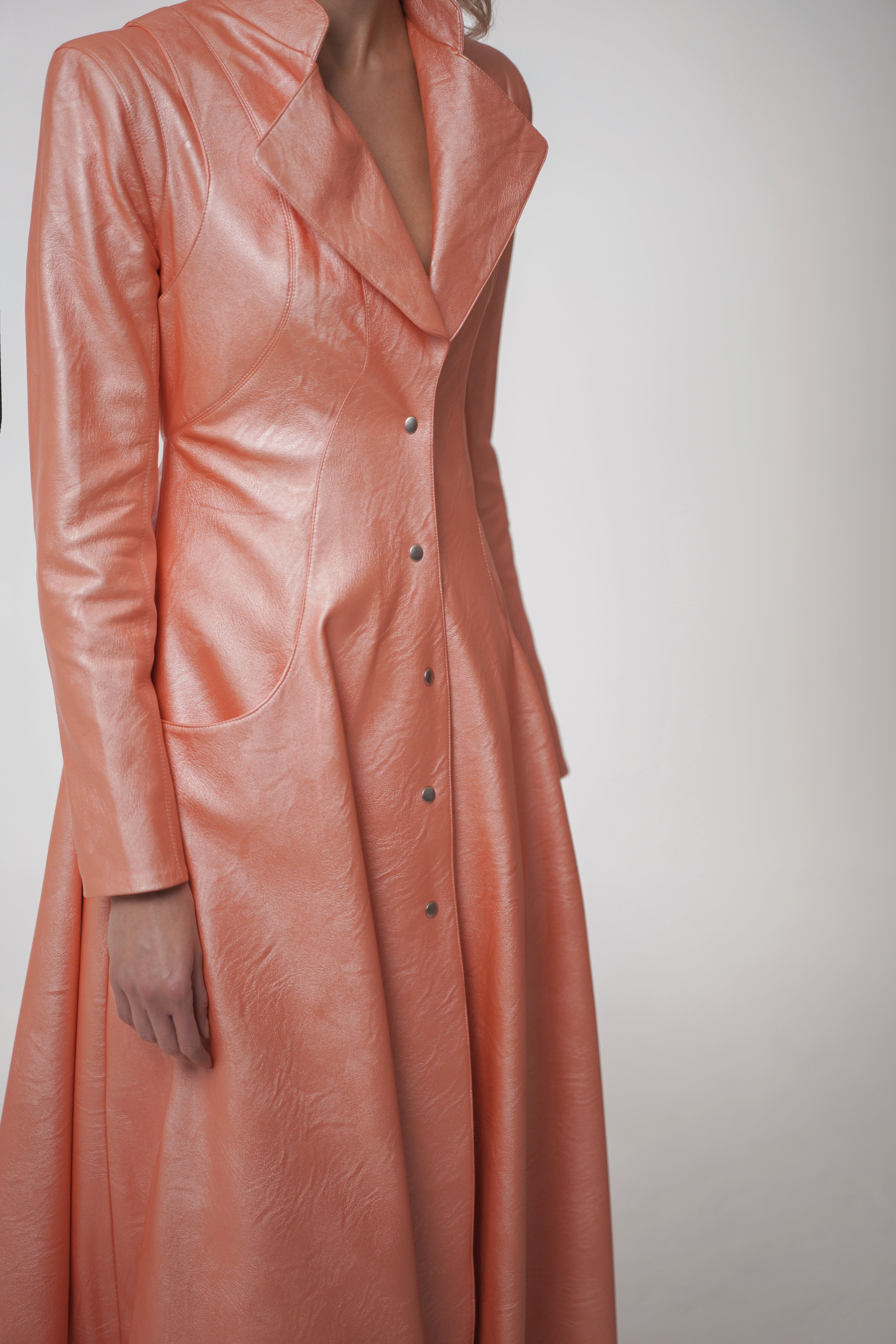 Woman wearing Matrix Coat from Mimaussy Paris in light pink, studio close-up of front details against a plain white background