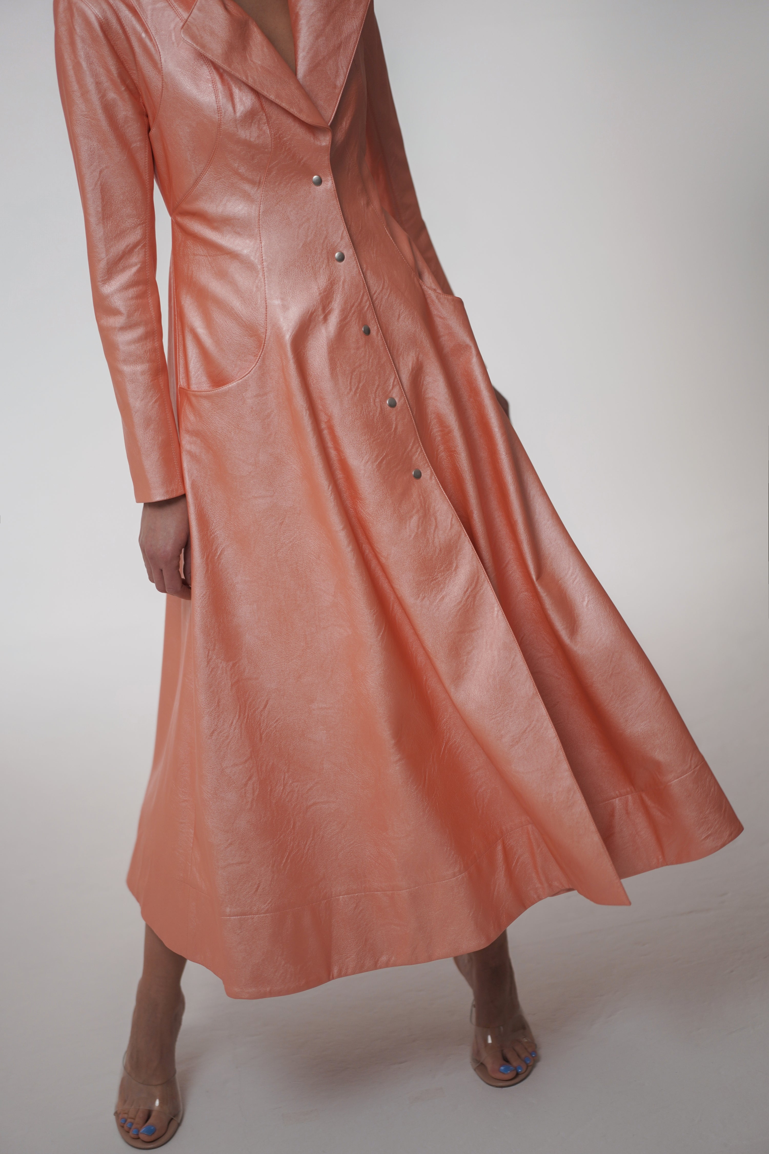 Woman wearing Matrix Coat from Mimaussy Paris in light pink, studio close-up of front details against a plain white background