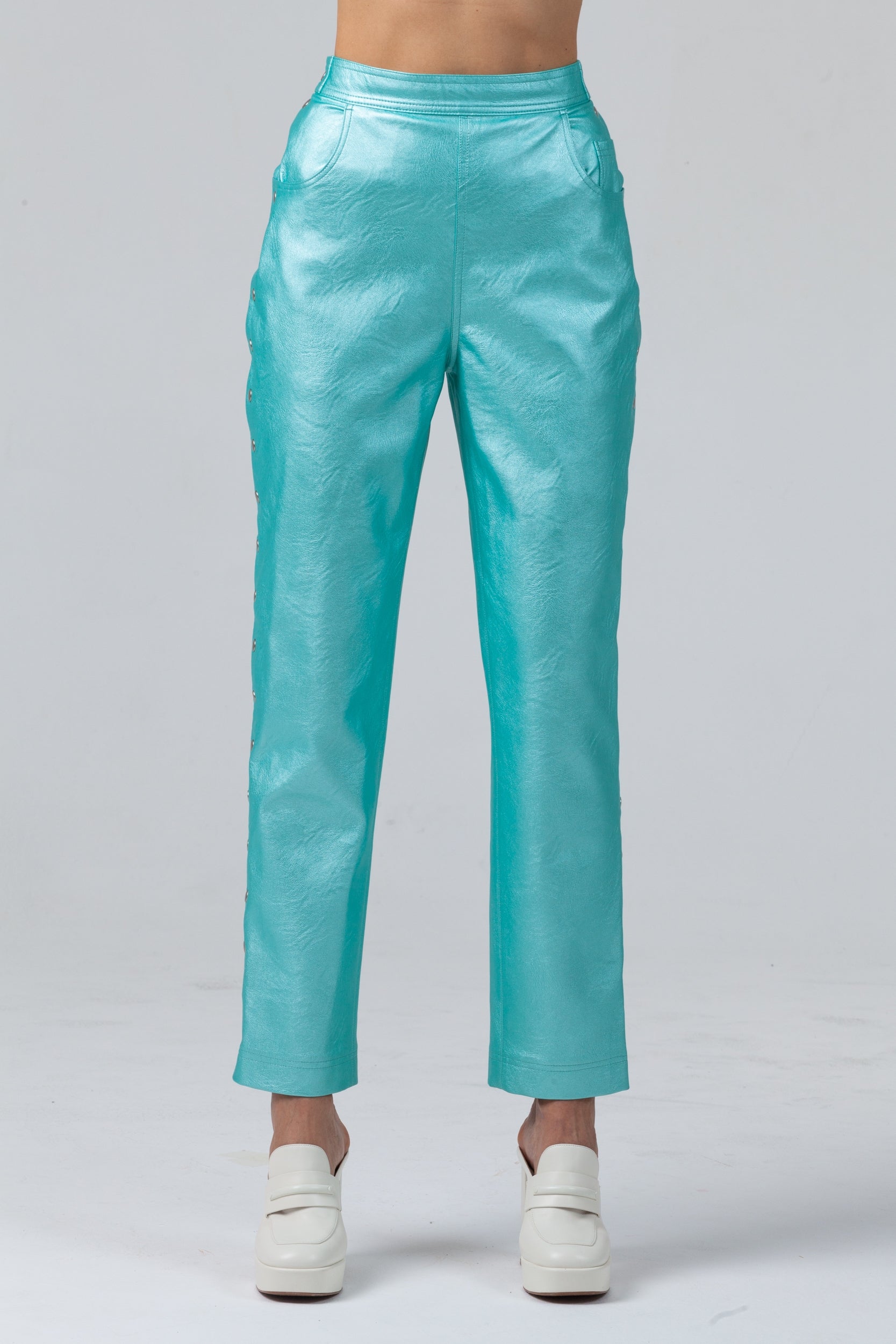 Woman wearing Matrix Eco-Leather Trousers from Mimaussy Paris in turquoise, front view studio shot against a plain white background