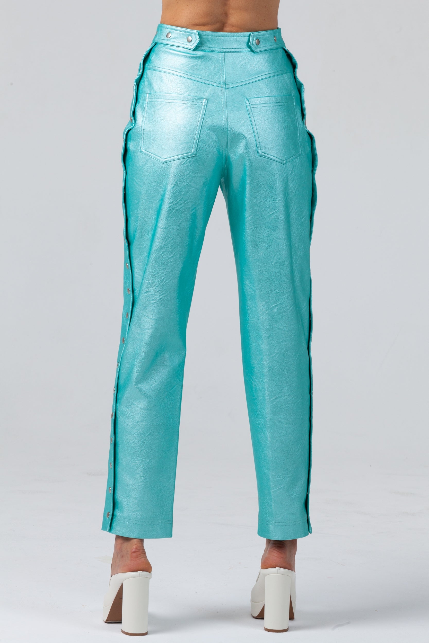 Woman wearing Matrix Eco-Leather Trousers from Mimaussy Paris in turquoise, detailed back view studio close-up against a plain white background