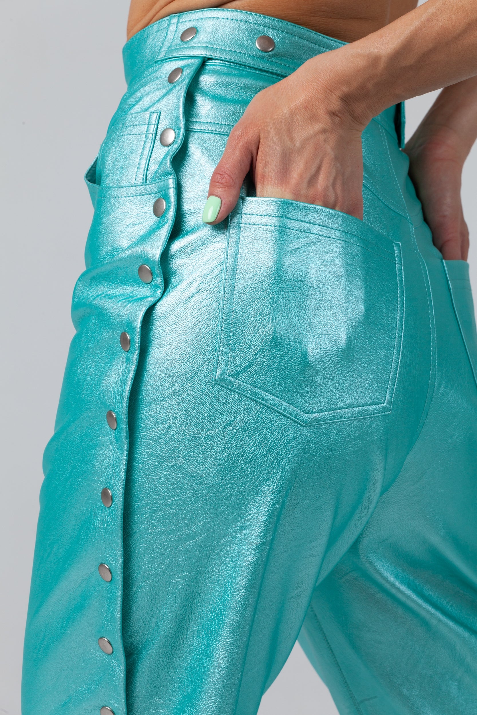 Woman wearing Matrix Eco-Leather Trousers from Mimaussy Paris in turquoise, detailed back view studio close-up of seat and upper thigh area against a plain white background