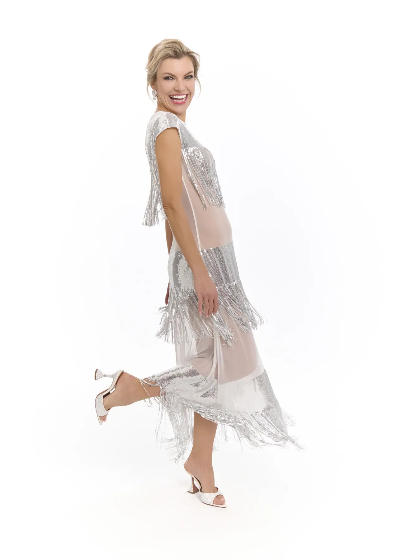 A woman models a silver Midnight Charleston Dress from Mimaussy Paris, striking a pose for the camera with confidence.