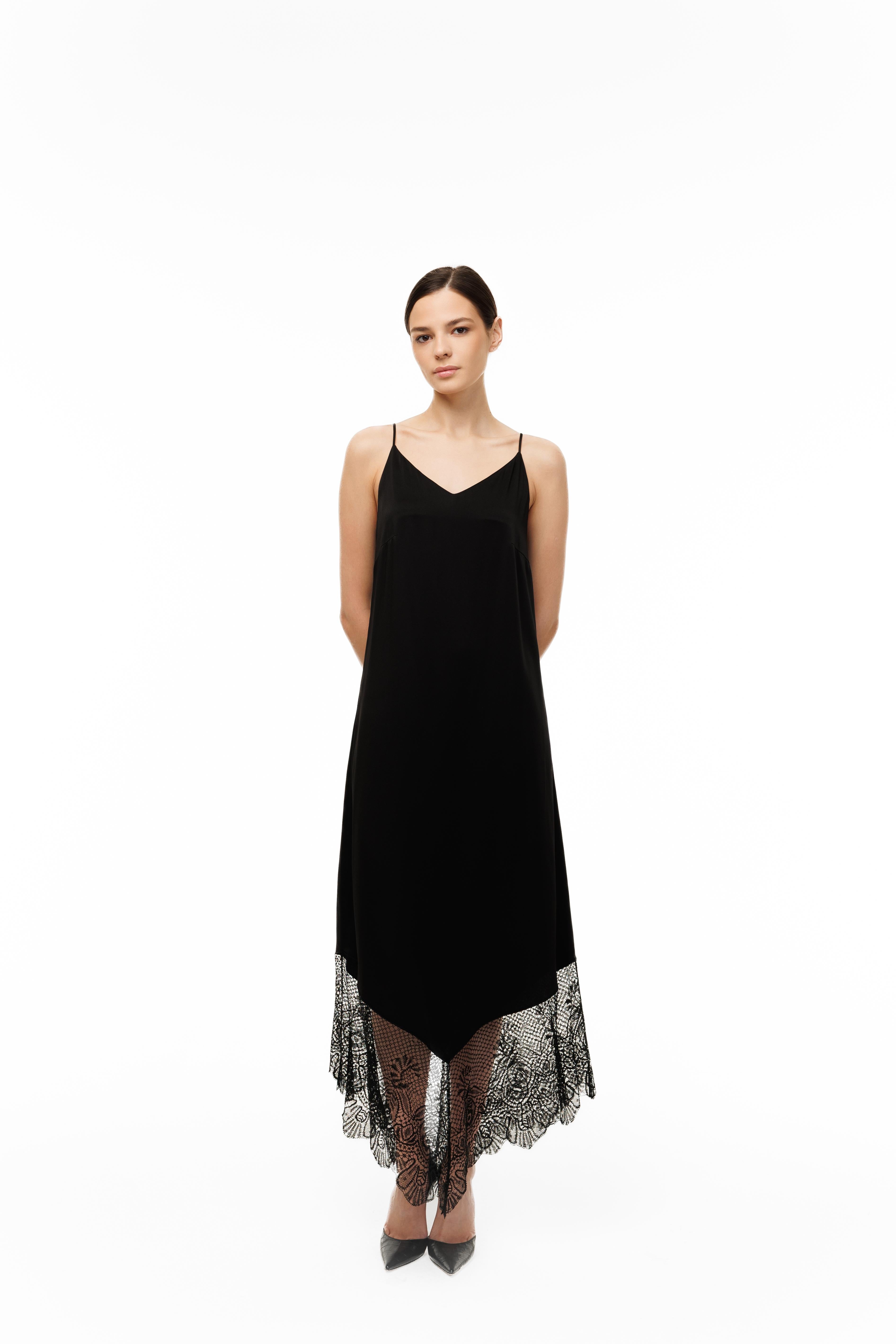 Black slip dress with lace hem on a white background