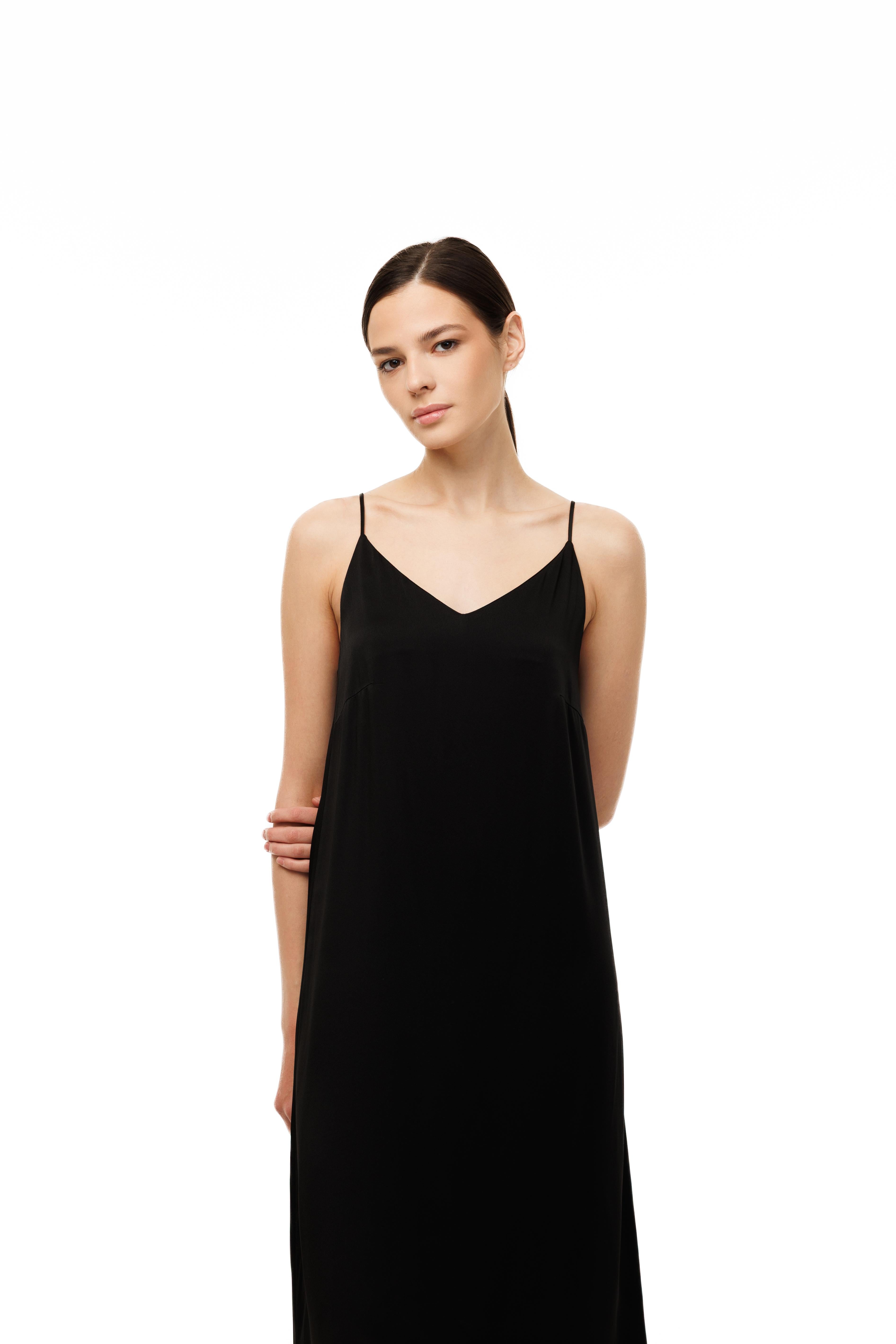 Woman wearing a black slip dress on a white background
