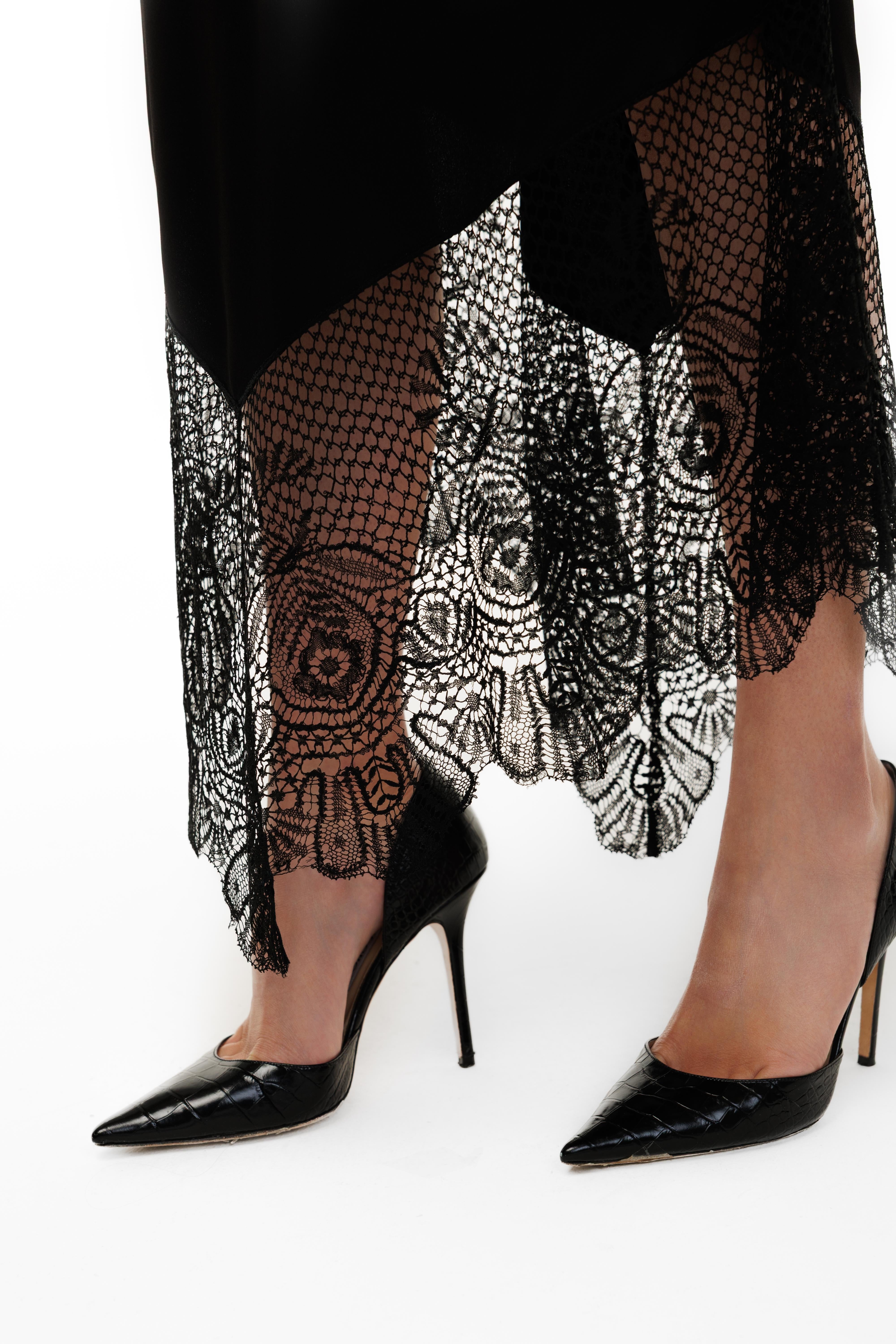 Person wearing black high-heeled shoes and fishnet stockings with a pattern on a white background
