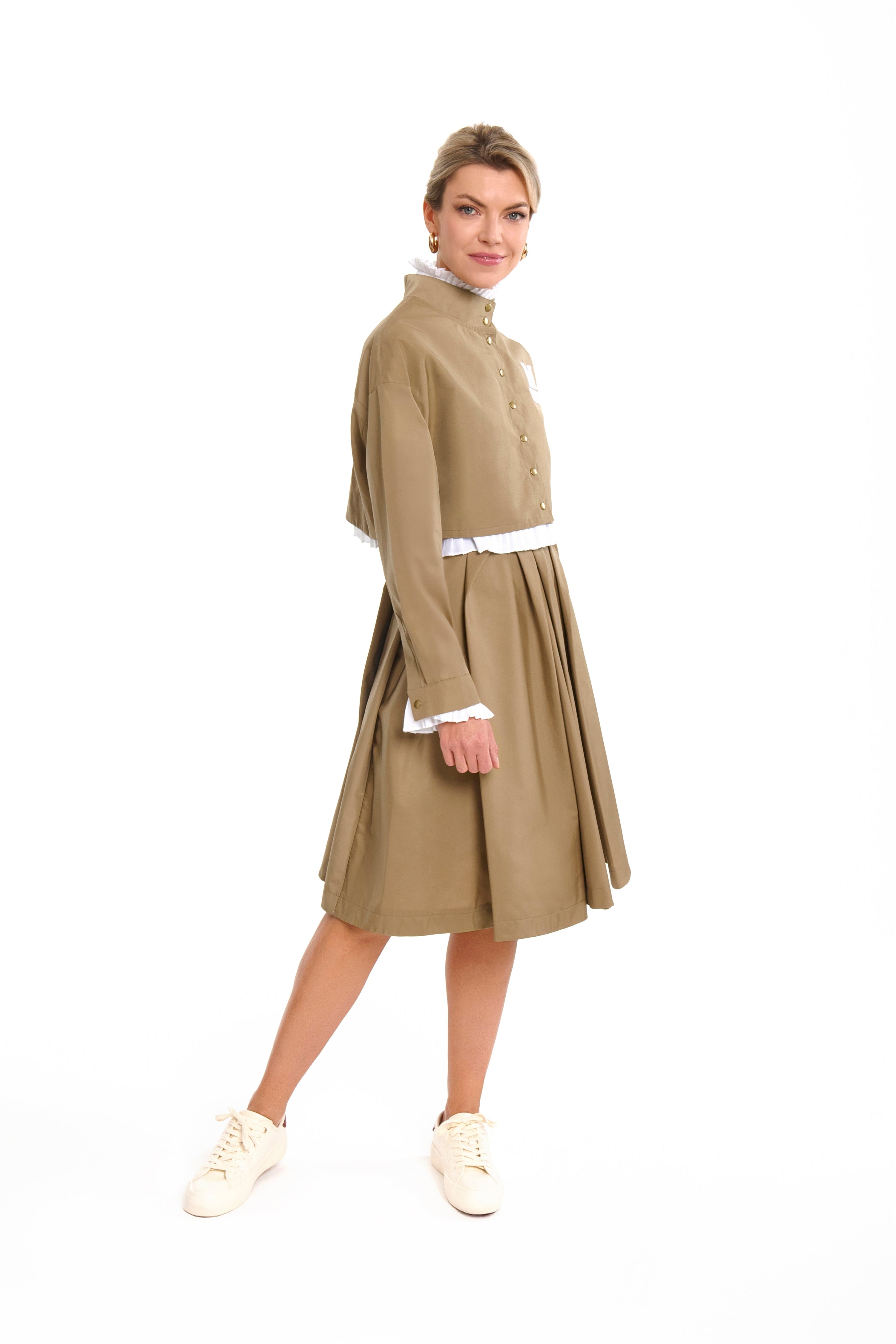 Woman wearing a Parisien Cropped Trench Jacket from Mimaussy Paris, beige dress with a white collar, on a white background