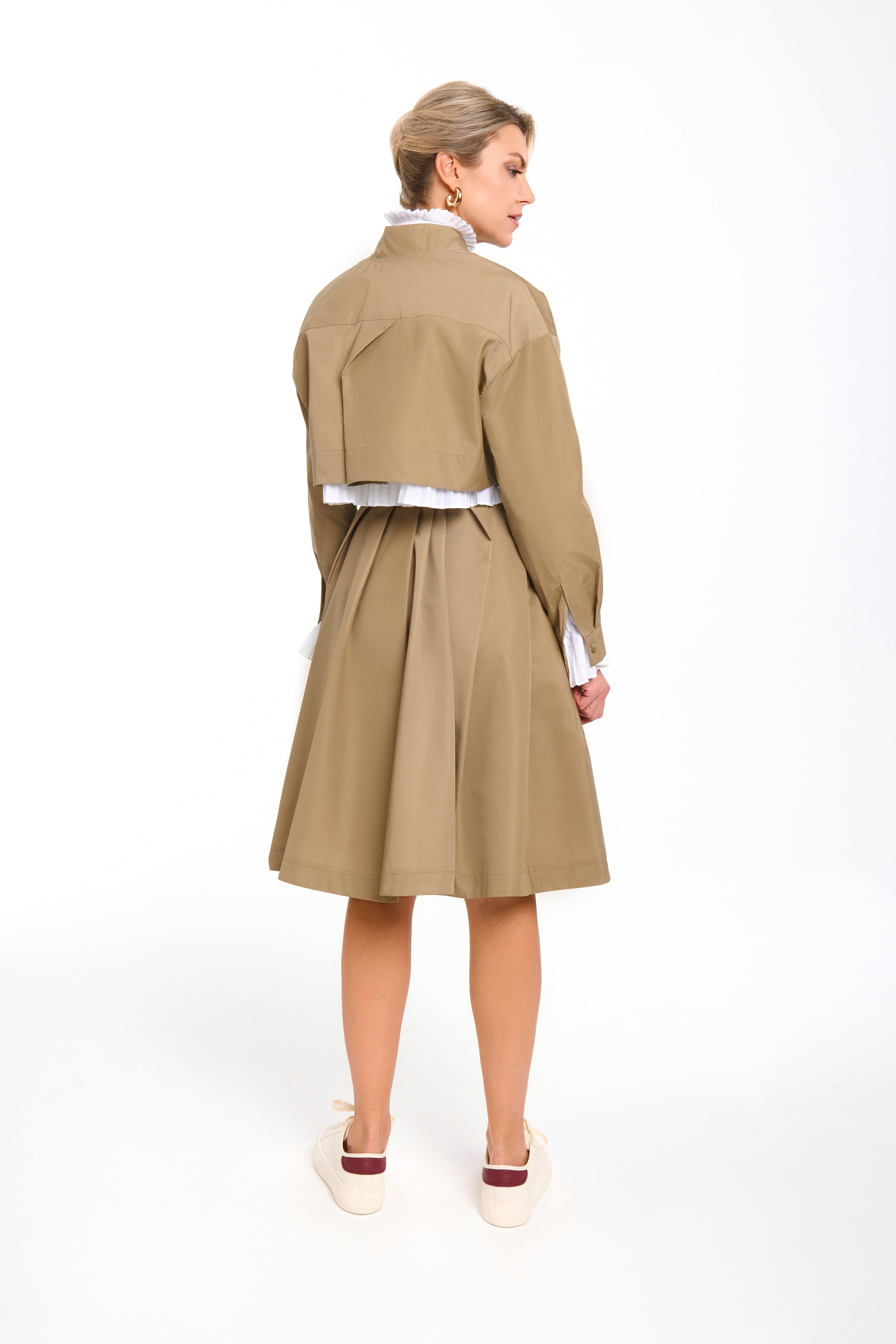 Woman wearing a Parisien Cropped Trench Jacket from Mimaussy Paris, beige trench coat, on a white background