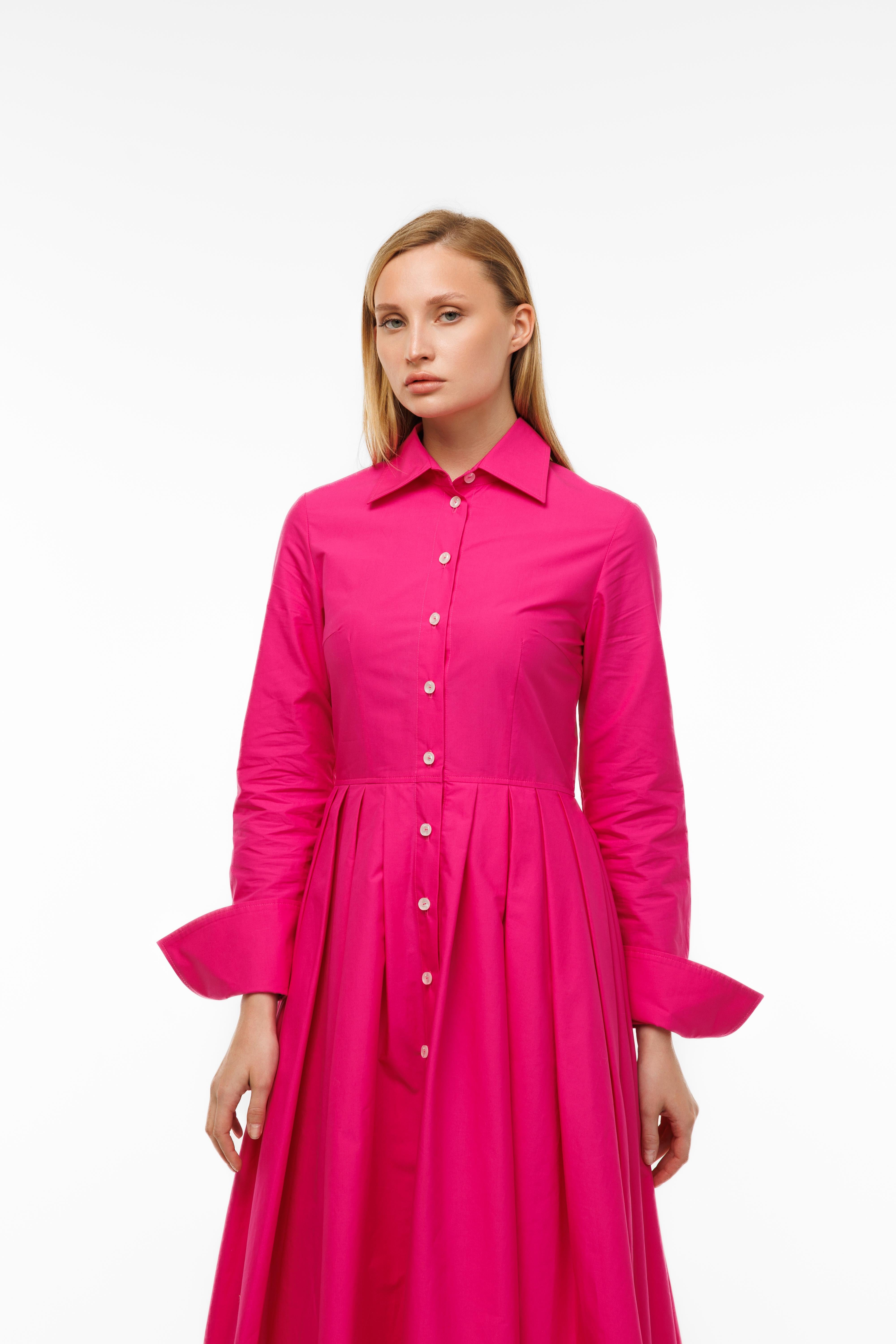 Woman wearing a bright pink dress with a white background